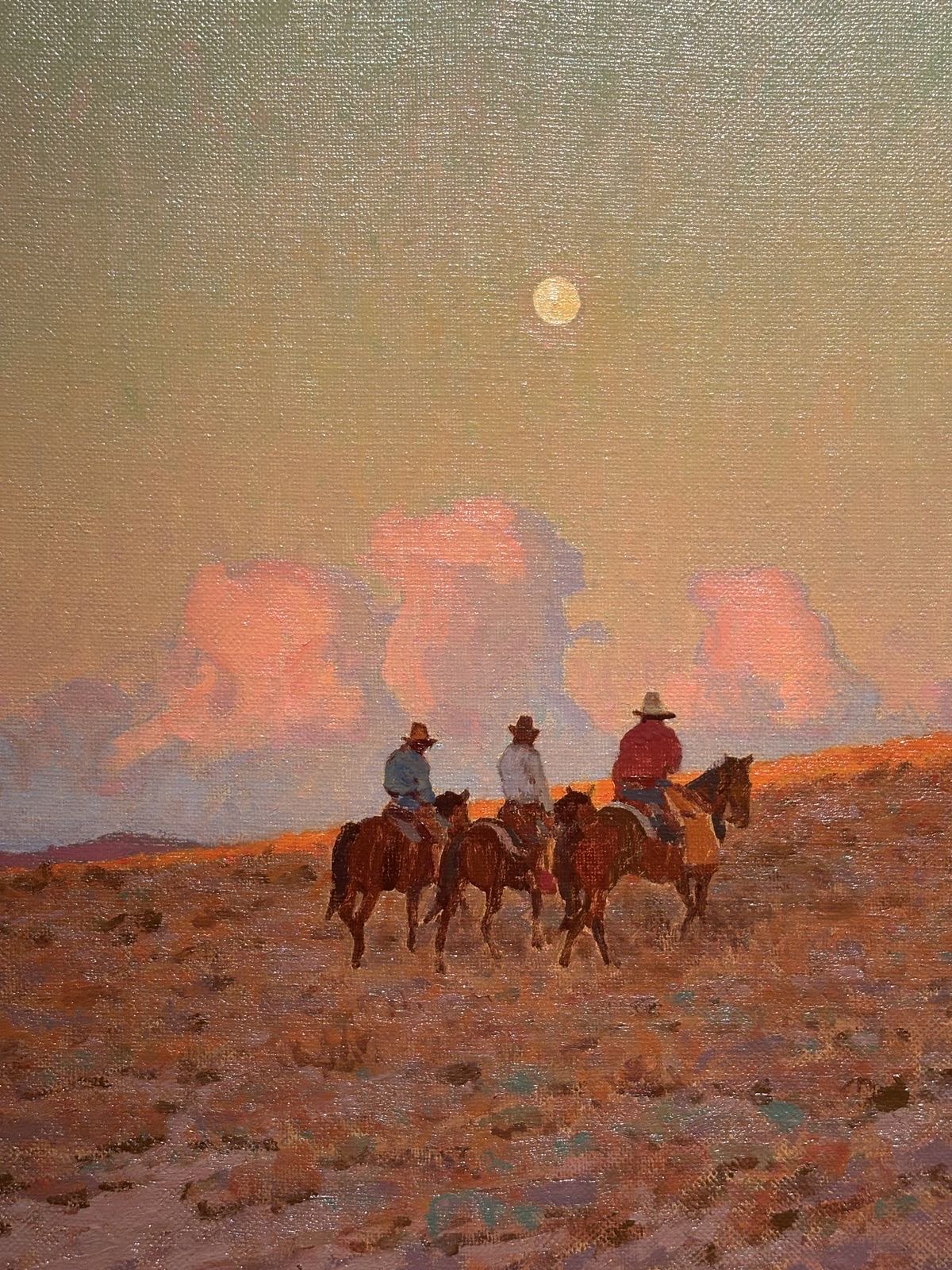 Three cowboys on horseback riding across a dusty plain under a full moon with pink storm clouds at sunset