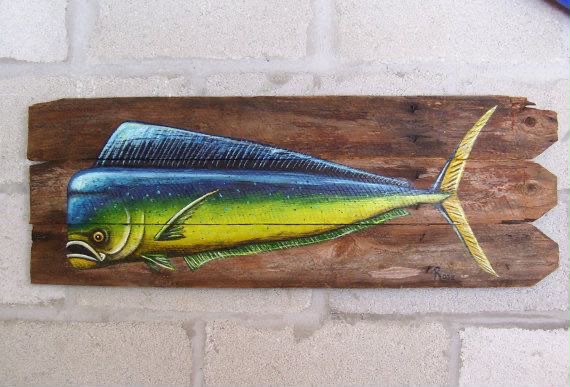 Mahi-mahi dorado fish painted on rustic reclaimed wooden planks against a white brick wall