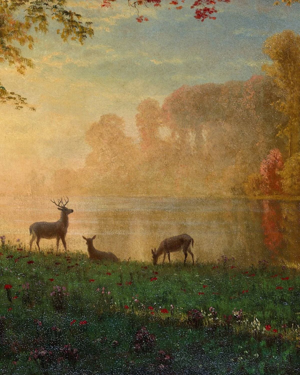 Three deer — a stag, a fawn, and a doe — grazing by a golden misty autumn lake with red wildflowers