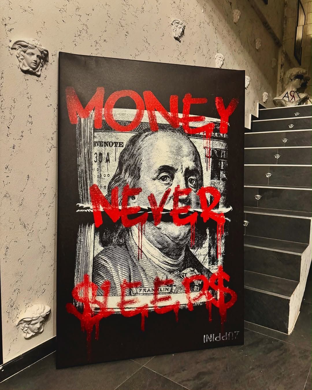 Black canvas with a $100 bill portrait of Benjamin Franklin and red dripping graffiti text reading Money Never Sleeps