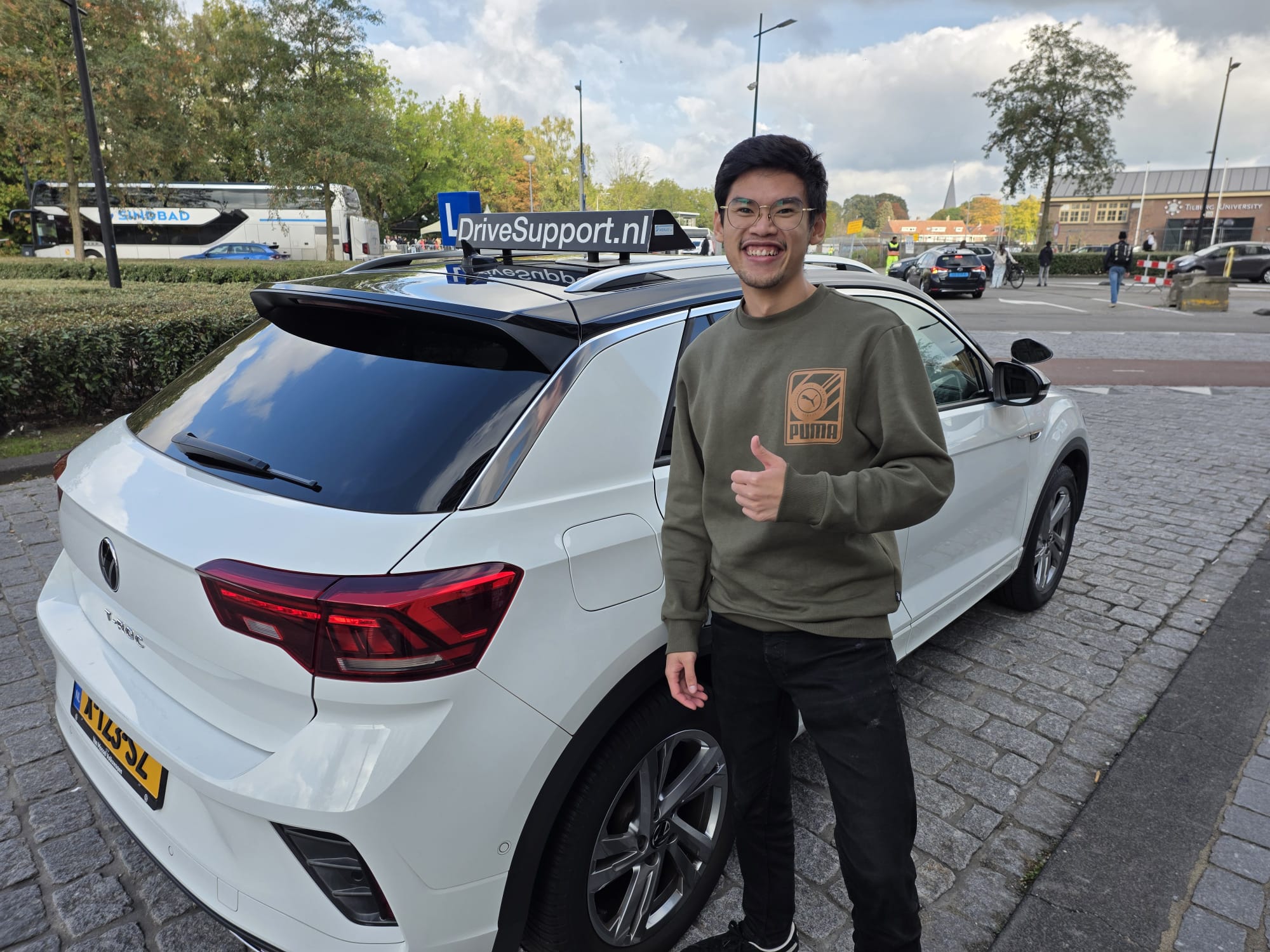 Geslaagde leerling bij Tilburg University naast DriveSupport T-Roc