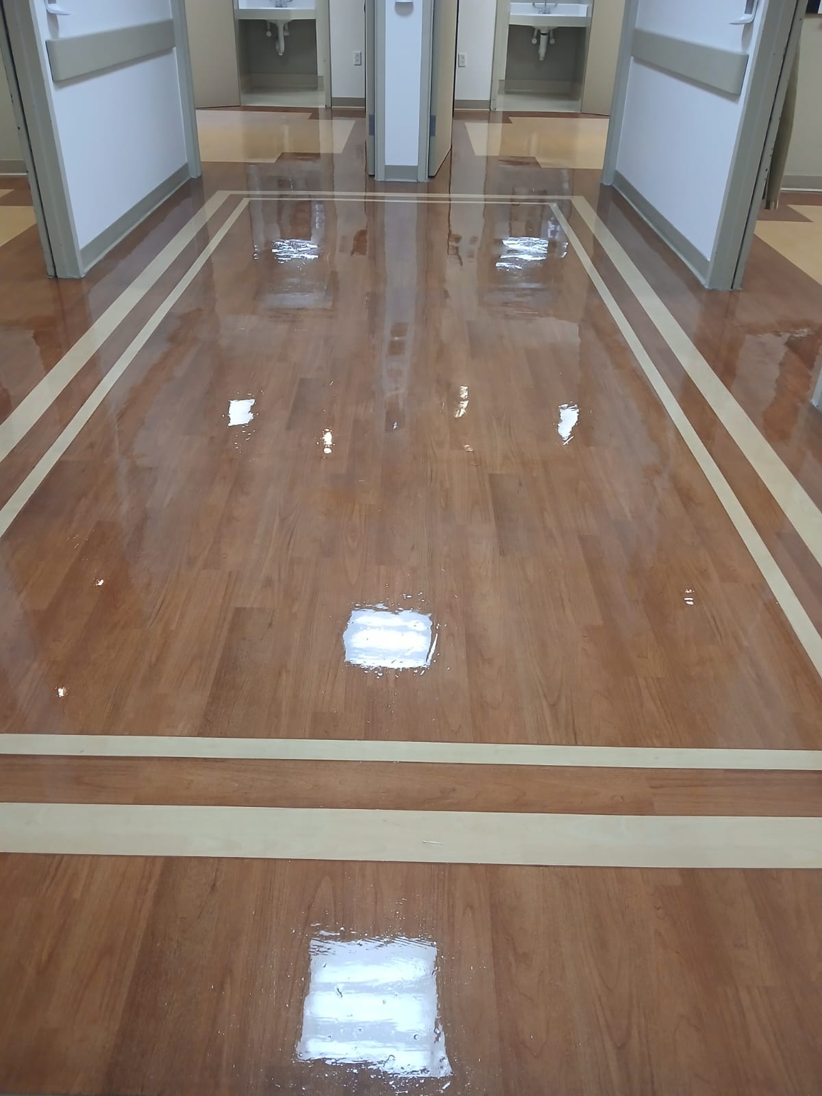 Medical facility hallway with freshly waxed VCT floor — mirror shine