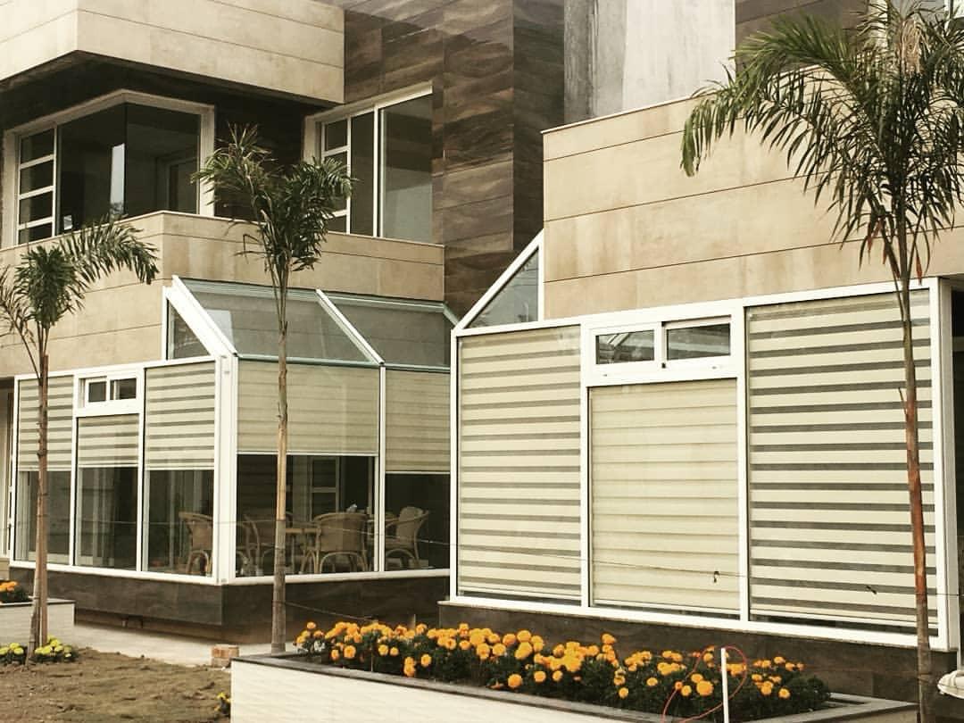 Cream and grey striped outdoor blinds on a modern villa facade by M.A Blinds & Curtains