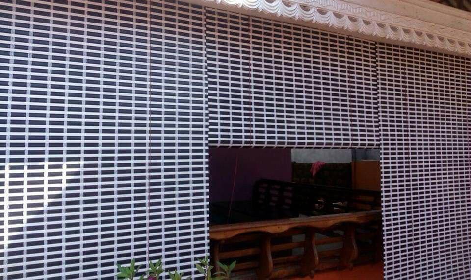 Black and white striped PVC outdoor blinds covering a veranda by M.A Blinds & Curtains