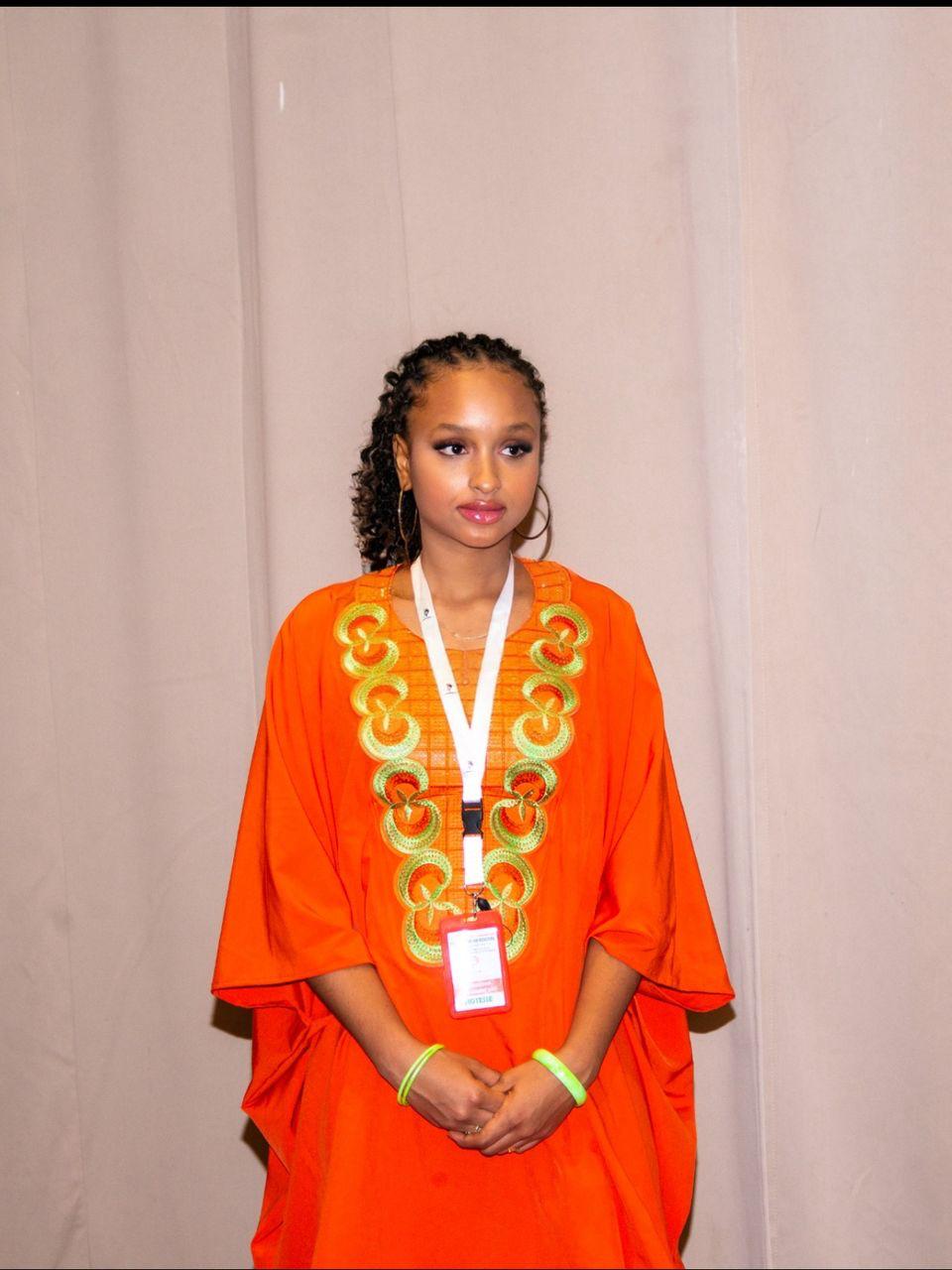 Hôtesse en tenue traditionnelle orange brodée