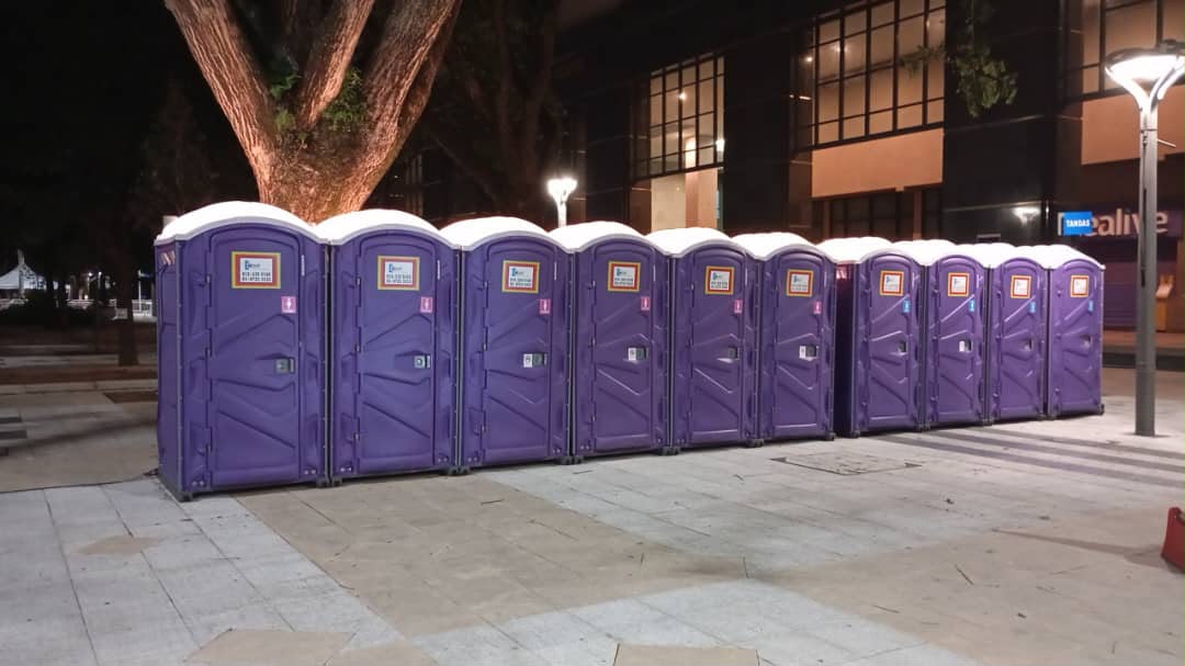 EQool Enviro purple portable toilets deployed at night for government event