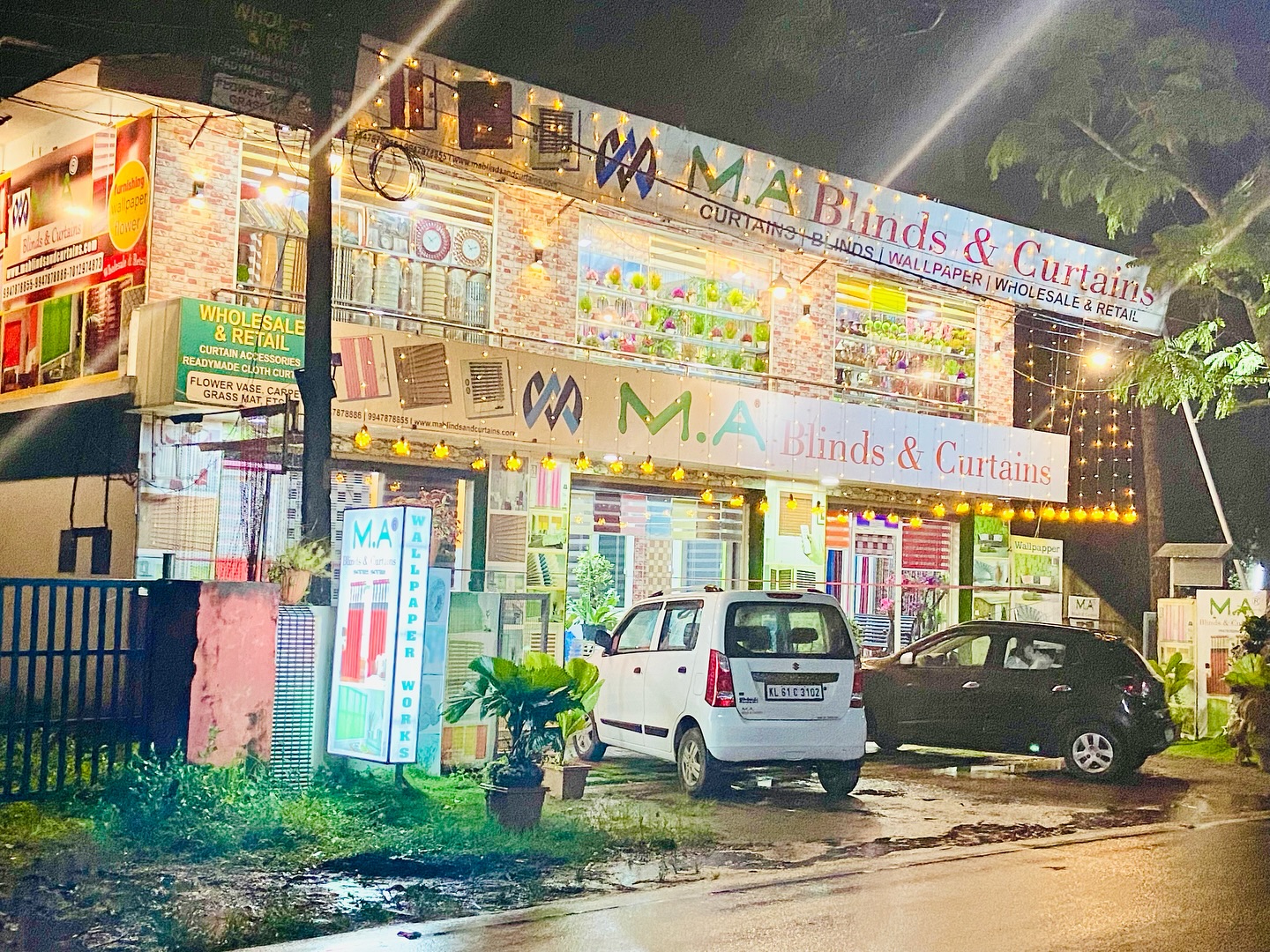 M.A Blinds & Curtains showroom exterior at night with illuminated displays by M.A Blinds & Curtains