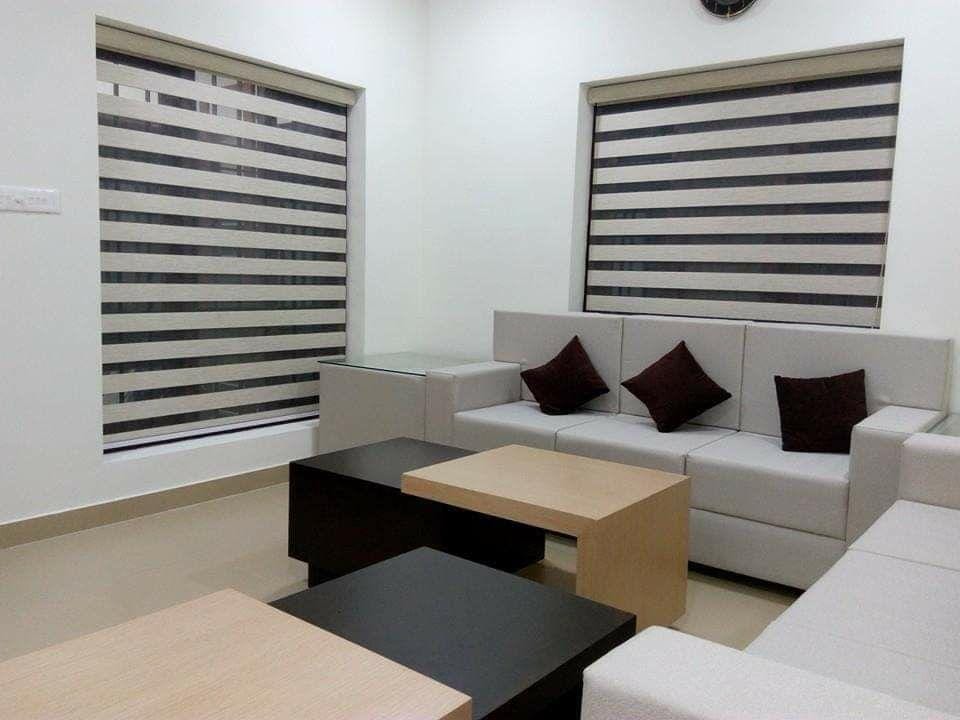 Modern living room with striped zebra blinds and contemporary furniture by M.A Blinds & Curtains