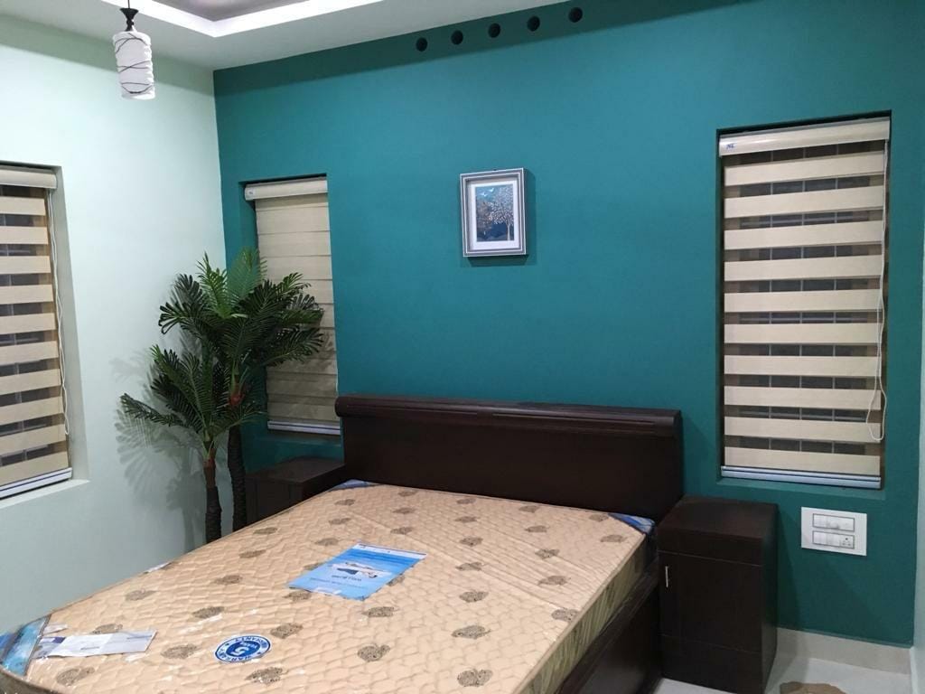 Bedroom with teal accent wall and cream striped zebra blinds by M.A Blinds & Curtains