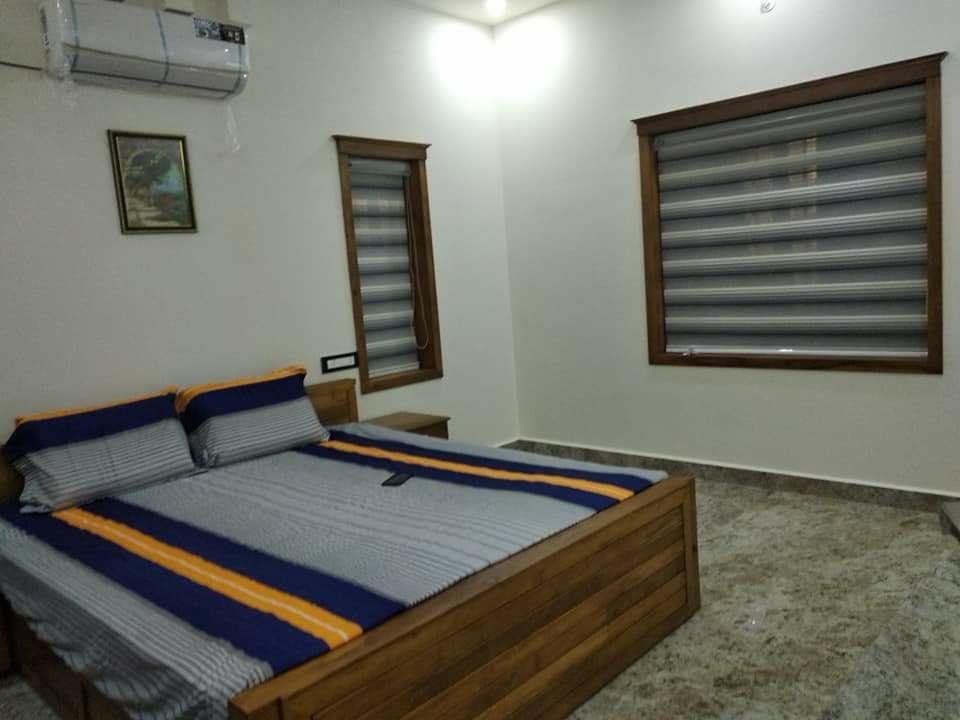 Bedroom with blue and orange striped bedding and wooden zebra blinds installation by M.A Blinds & Curtains