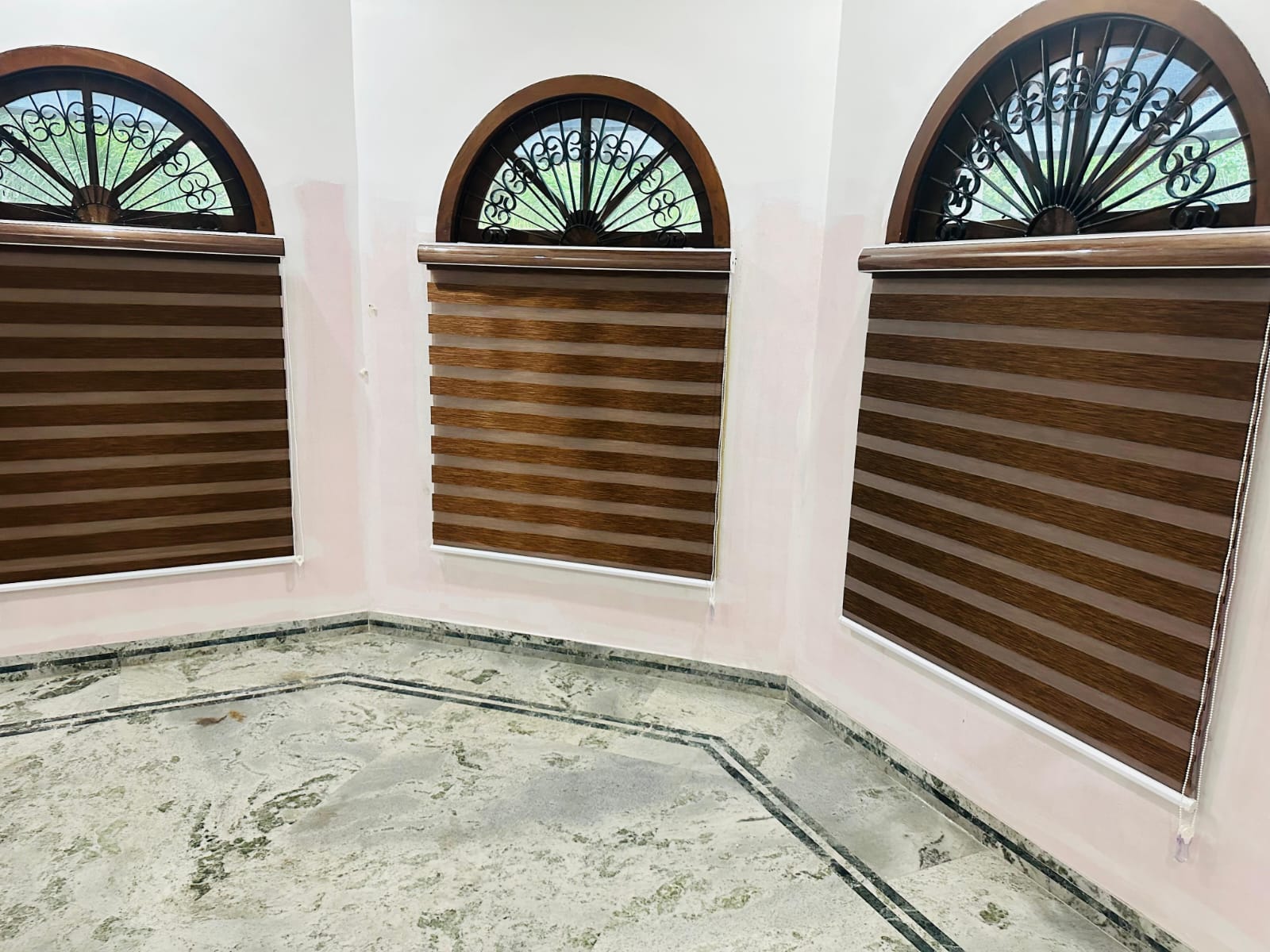 Decorative arched windows with brown wooden venetian blinds by M.A Blinds & Curtains