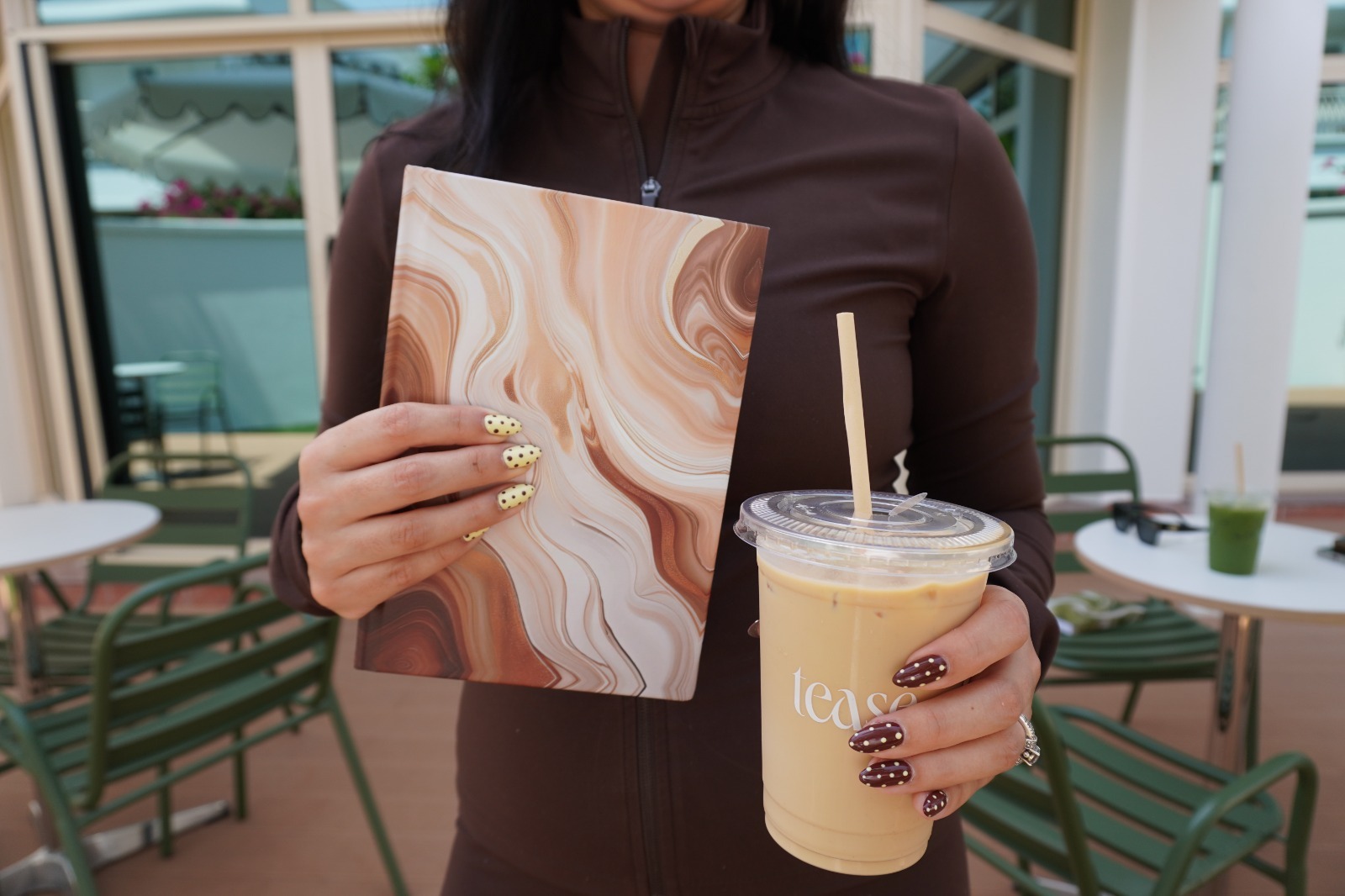 Caramel marble journal held next to an iced coffee