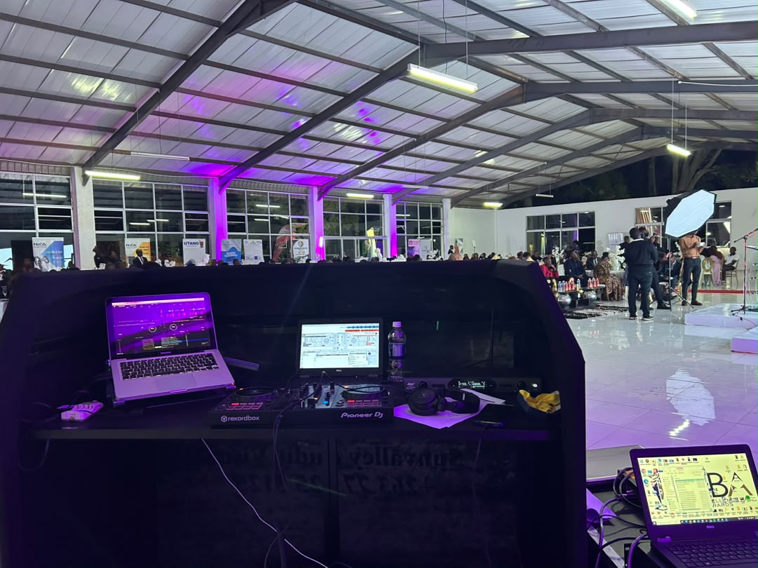 Professional DJ control room with purple ambient lighting, mixing console, and event production setup