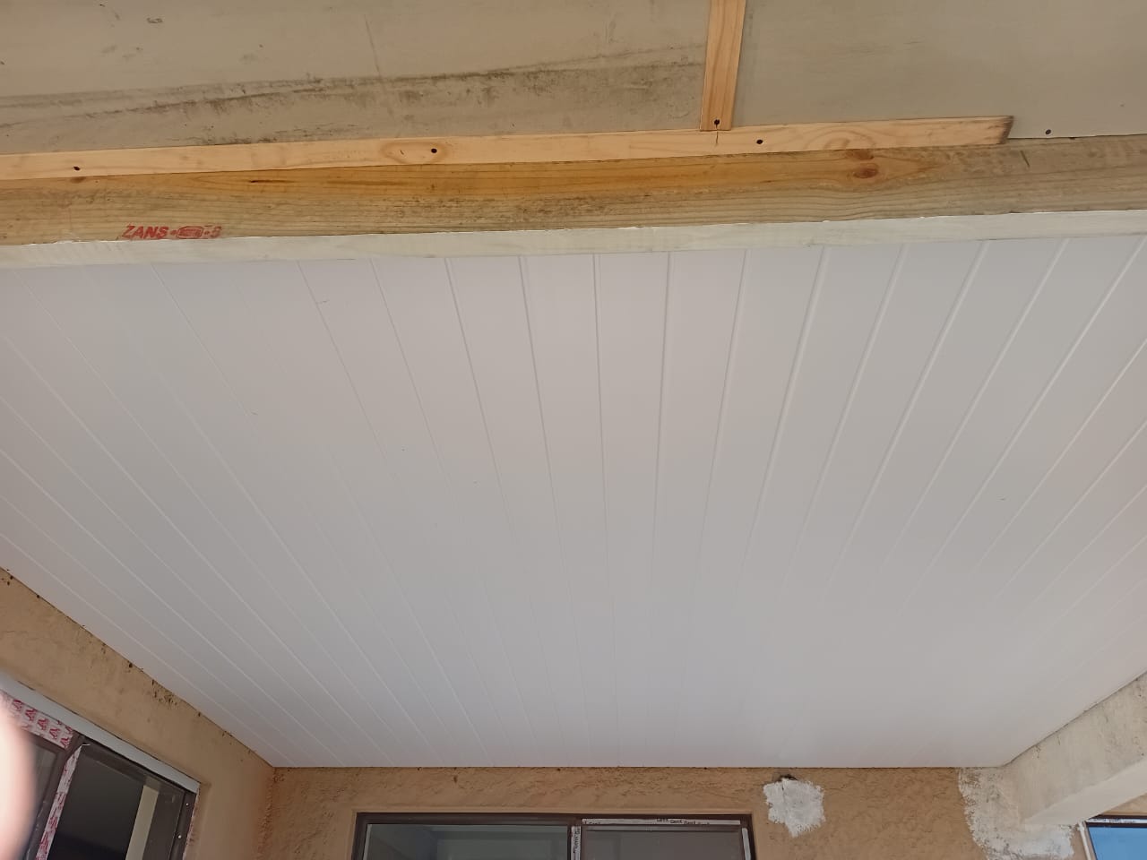 Completed flat roof ceiling Gqeberha — finished white plasterboard with vertical groove detail, LED cove lighting fixture preparation visible