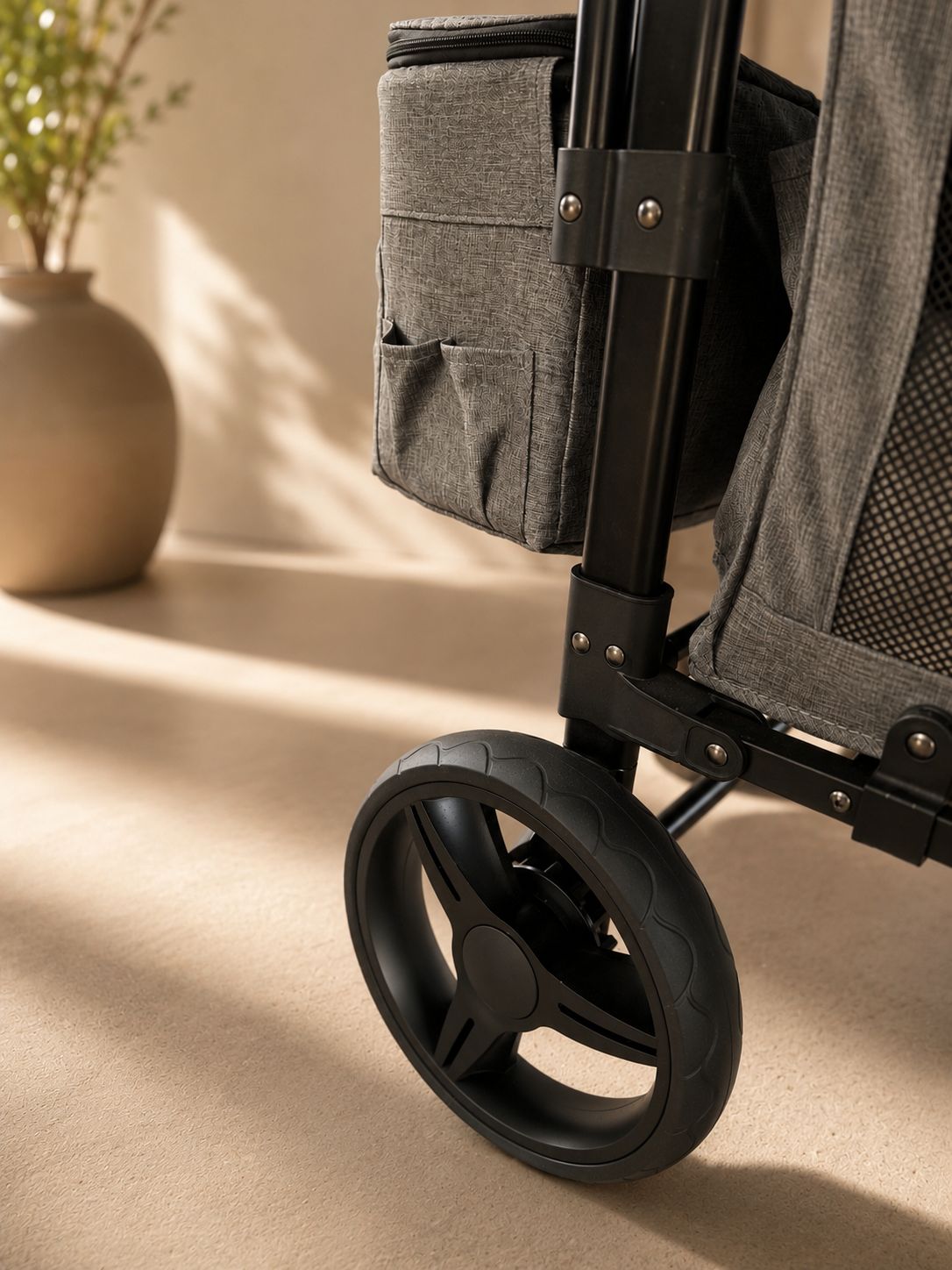 Detalhe da roda dianteira emborrachada e bolsa lateral do carrinho BÉPIE