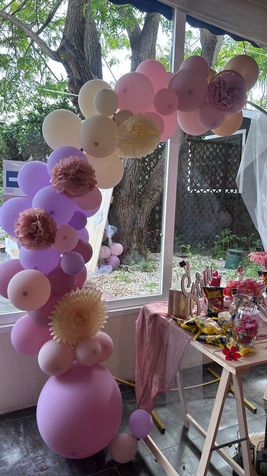 Arco de globos decorativo en terraza con árboles