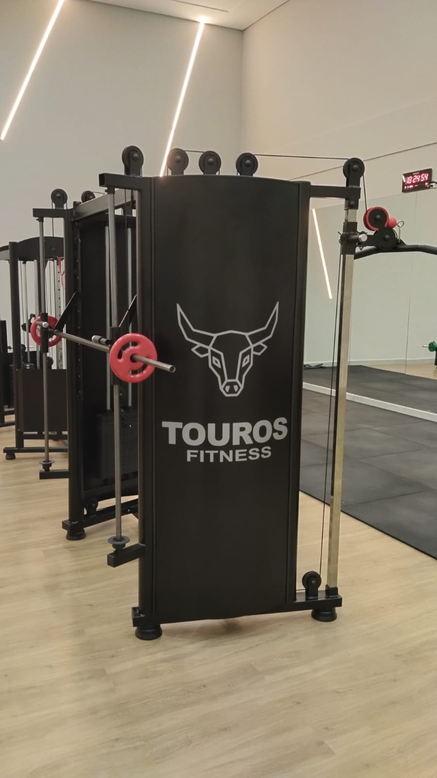 Functional trainer Touros Fitness com barras e anilhas vermelhas