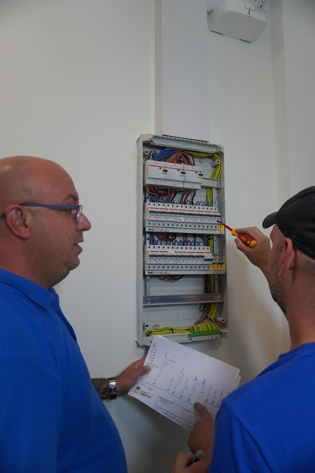 Deux techniciens ADY ART devant le tableau électrique