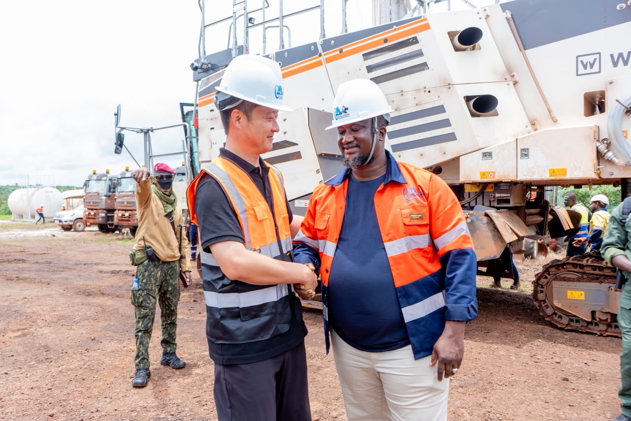 GHLEM leader greeting an operational partner beside mining machinery