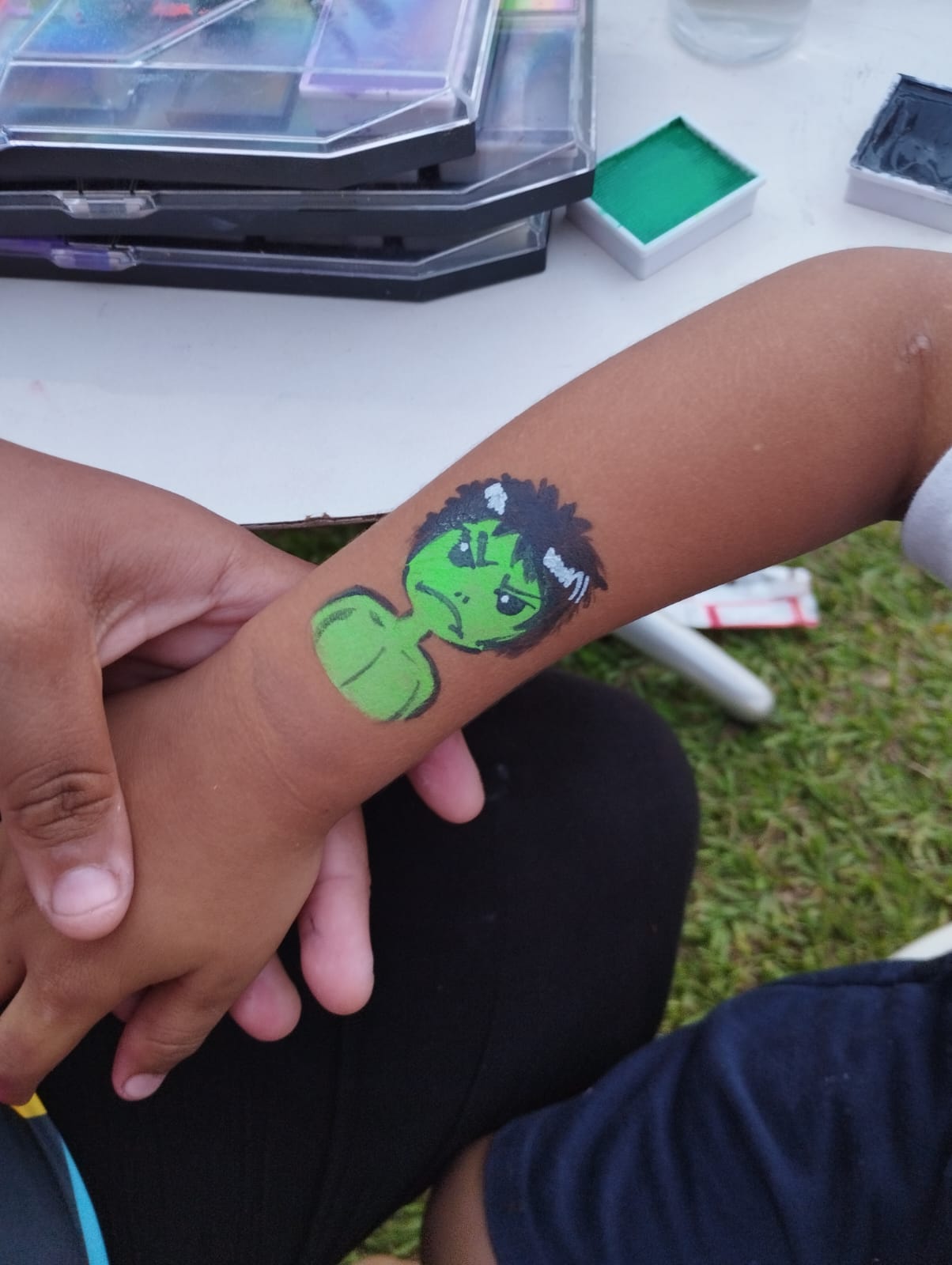 Pintura facial do Hulk no braço de uma criança