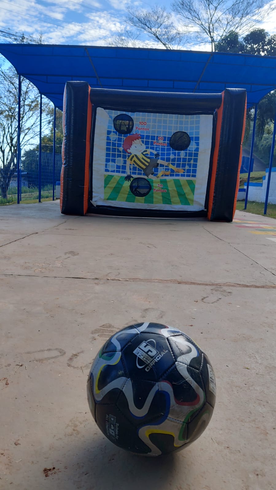 Gol inflável de futebol com alvos de pontuação e uma bola no chão