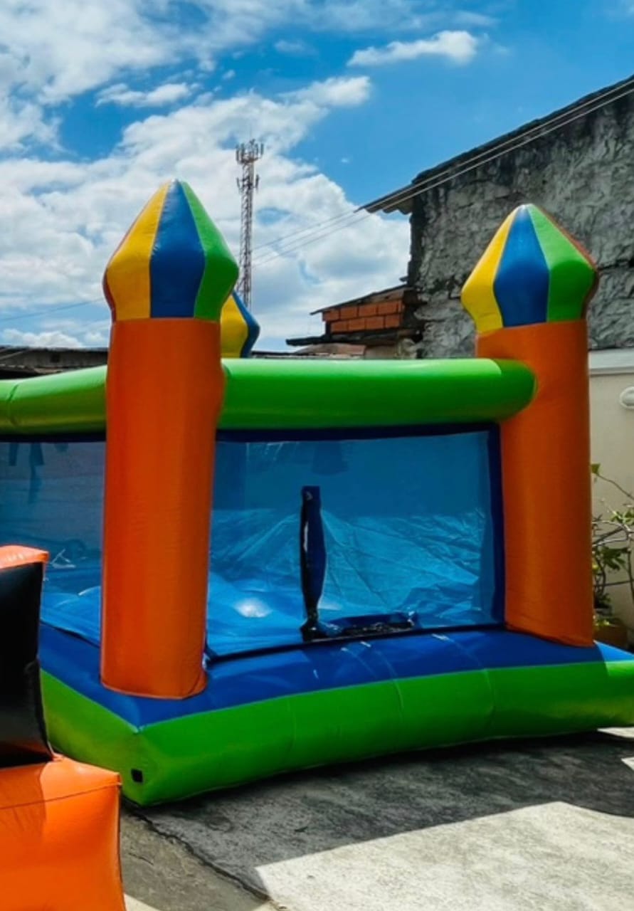 Castelo inflável colorido azul, verde, laranja e amarelo montado ao ar livre
