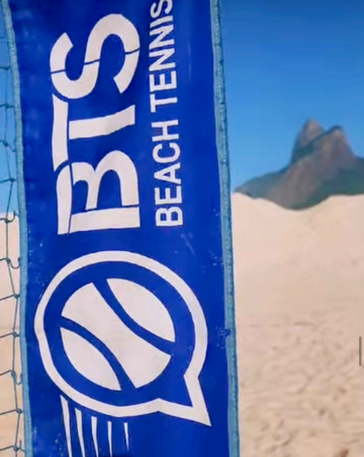 Faixa da BTS Beach Tennis na rede com o Morro Dois Irmãos ao fundo