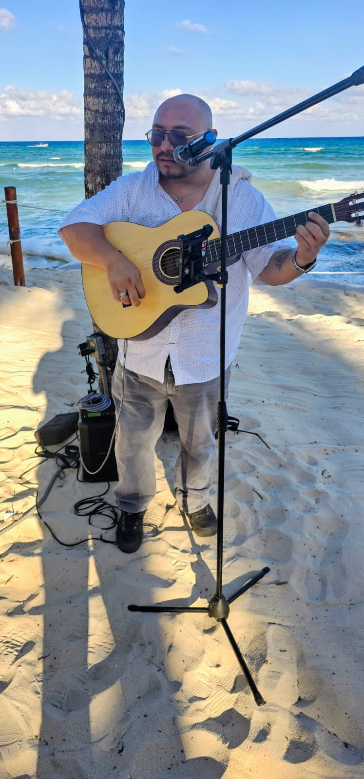 Daniel tocando guitarra frente al mar
