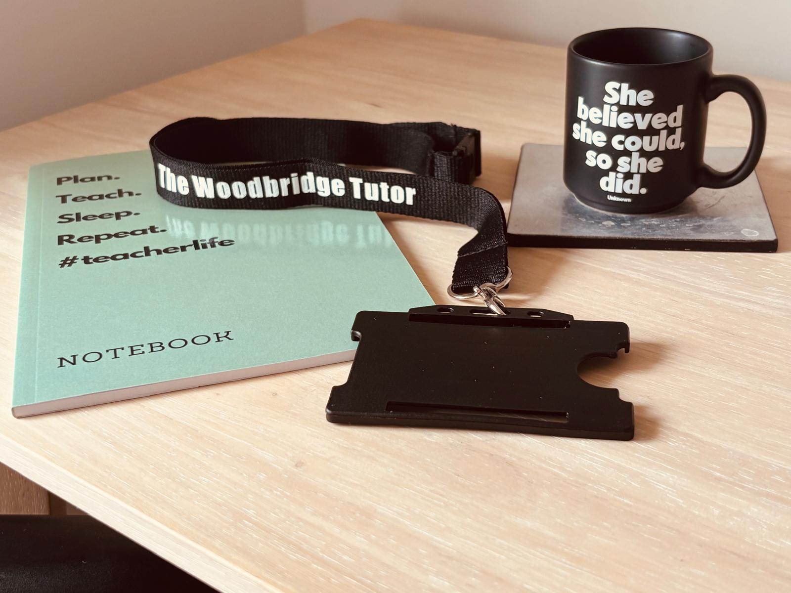 The Woodbridge Tutor lanyard and notebook on a teaching desk