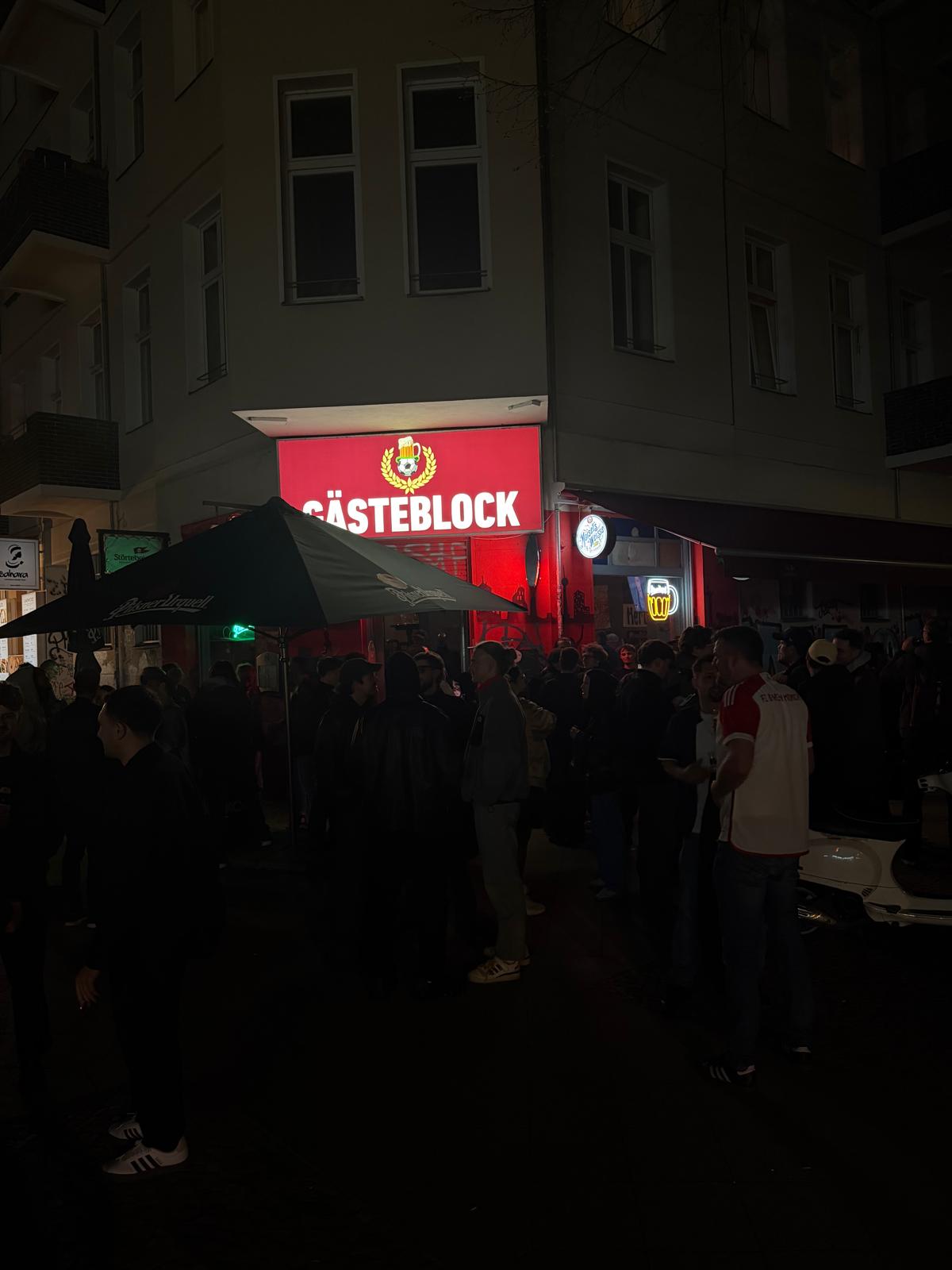 Gästeblock exterior at night with a busy crowd outside