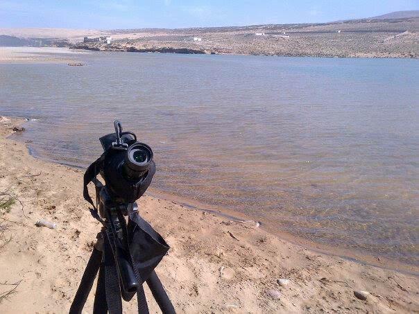 Spotting scope positioned beside a calm lake