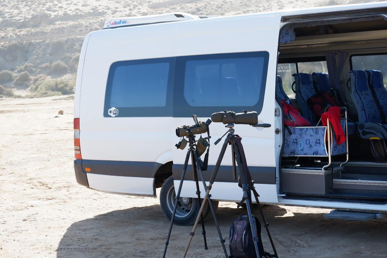 Birdwatching scopes set up beside a field vehicle
