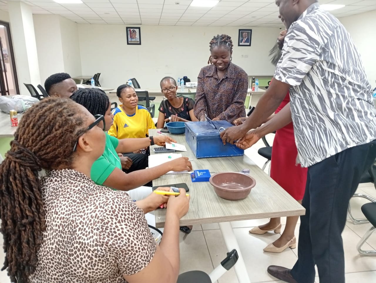 Community members seated around a table during Village Savings and Loan Association training