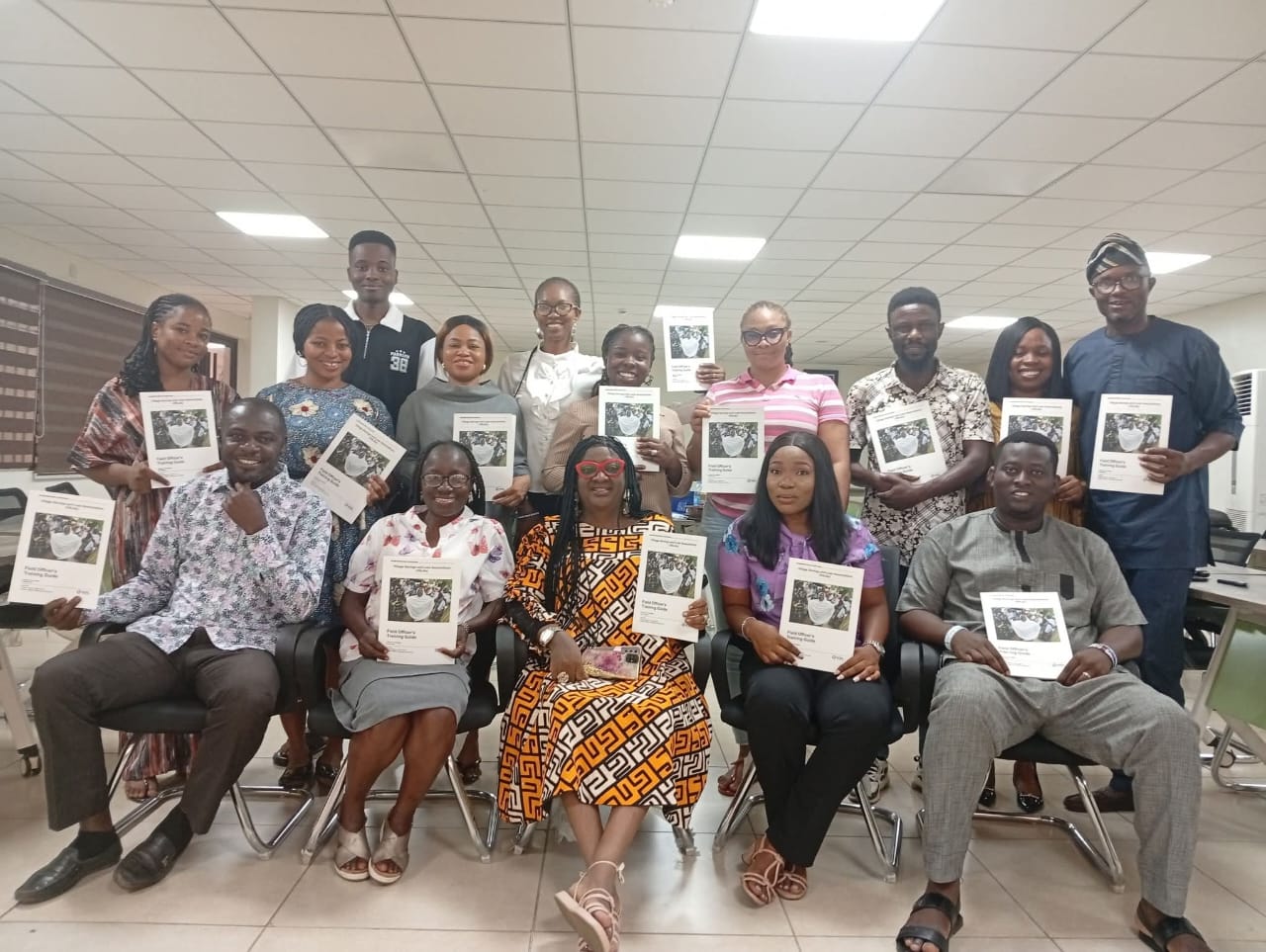 Field officers and partners holding copies of the Field Officer’s Training Guide