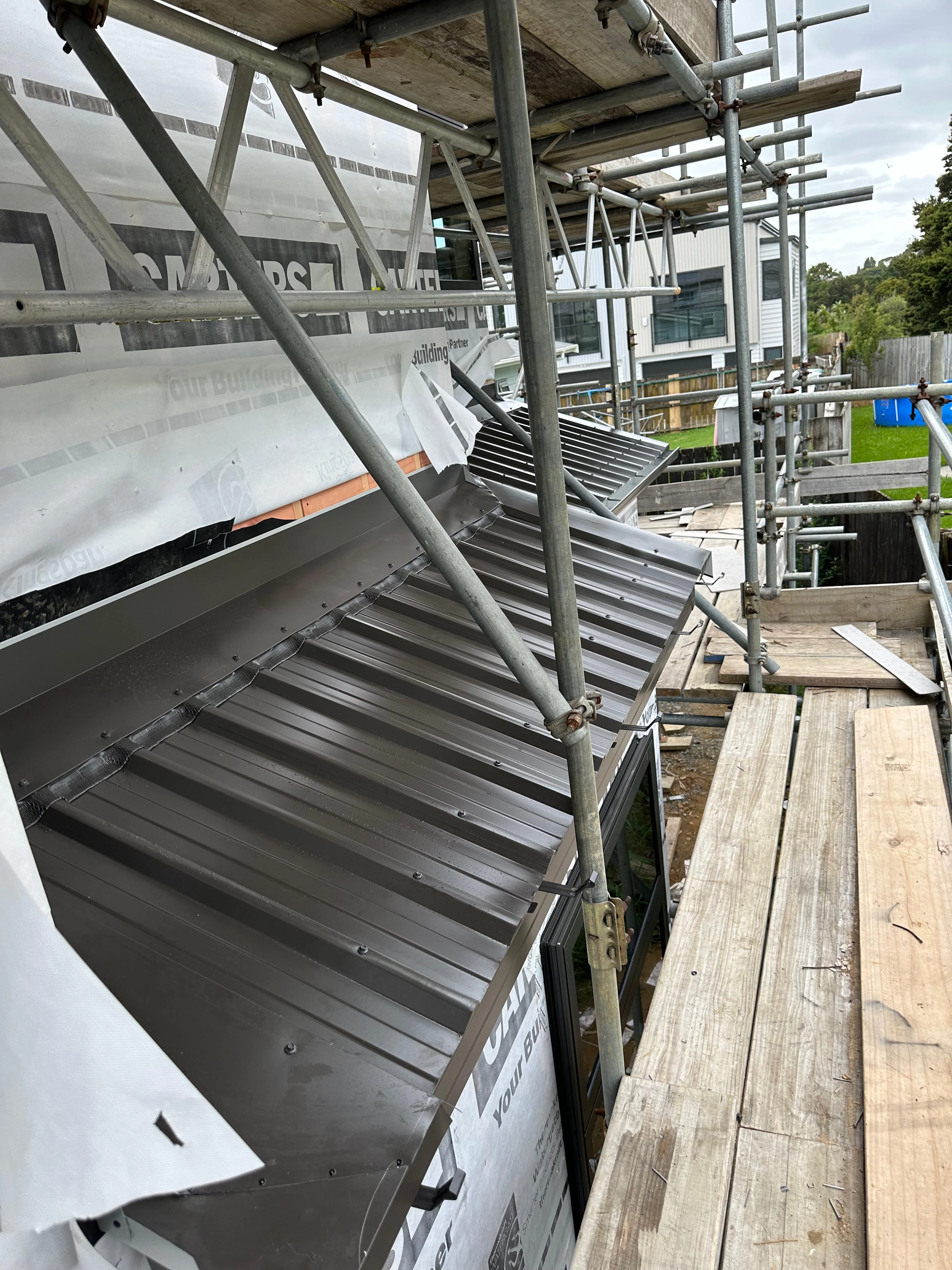 Roof installation in progress with safety scaffolding