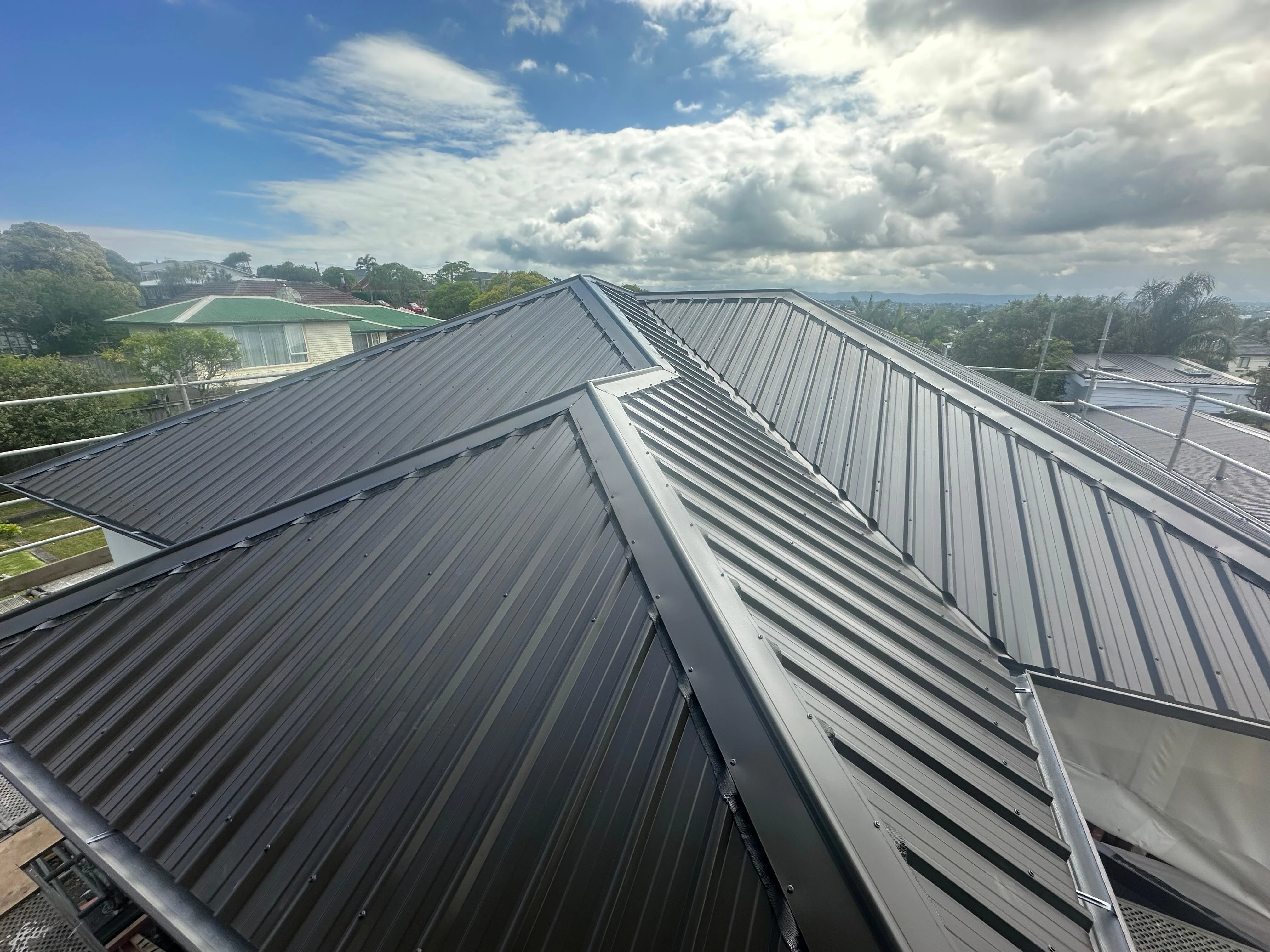 Completed dark metal roof with ridge flashing