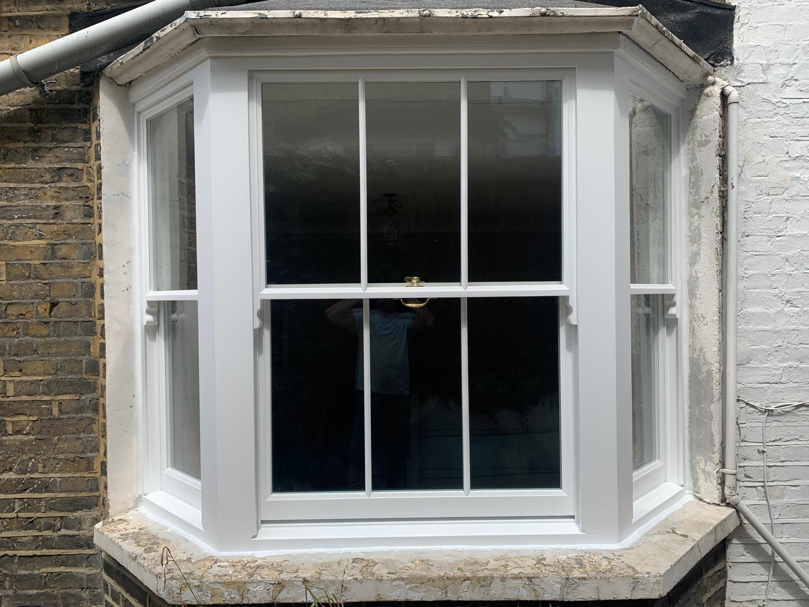 Freshly restored white timber bay sash window on a period property