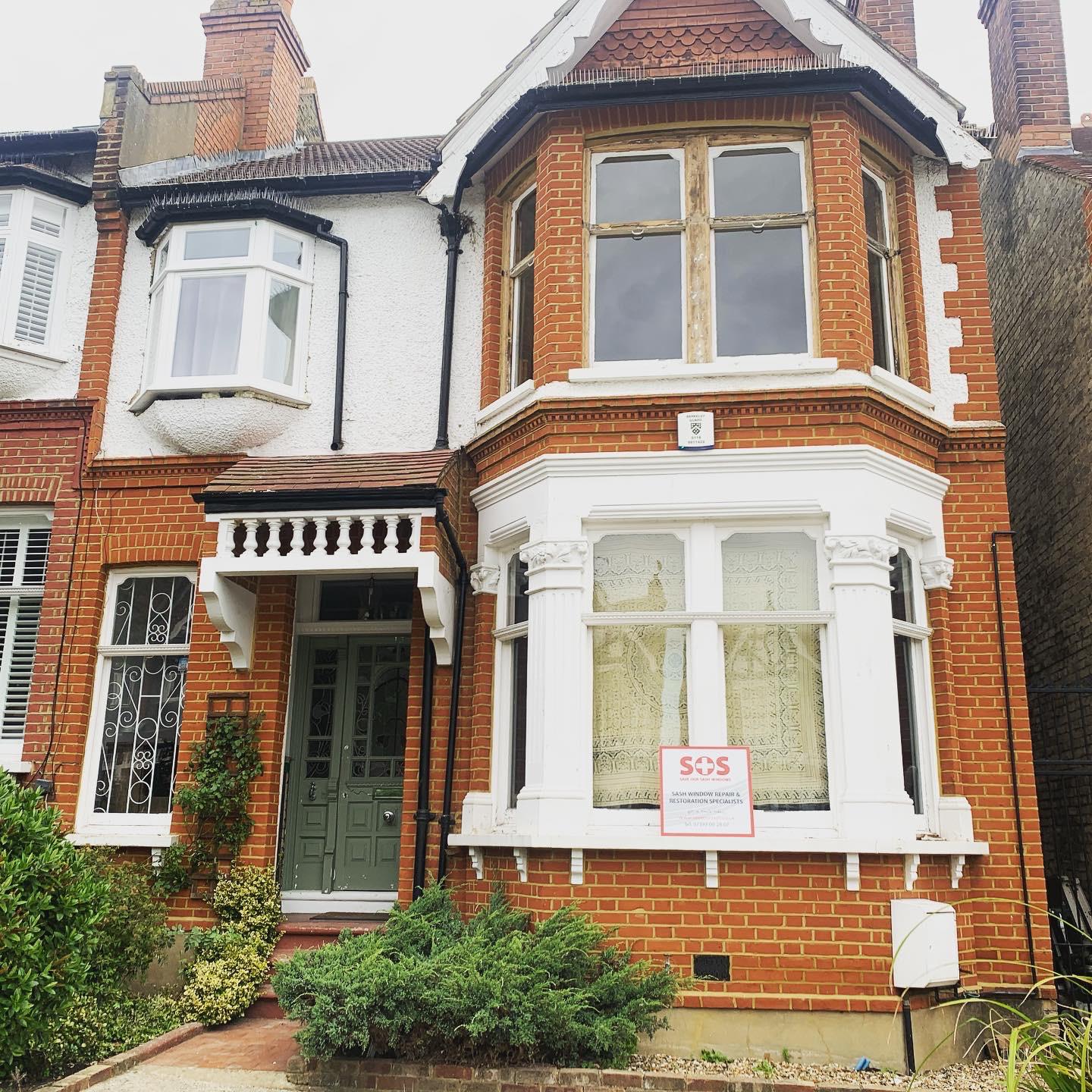 Restored period sash windows on a red-brick London terraced home