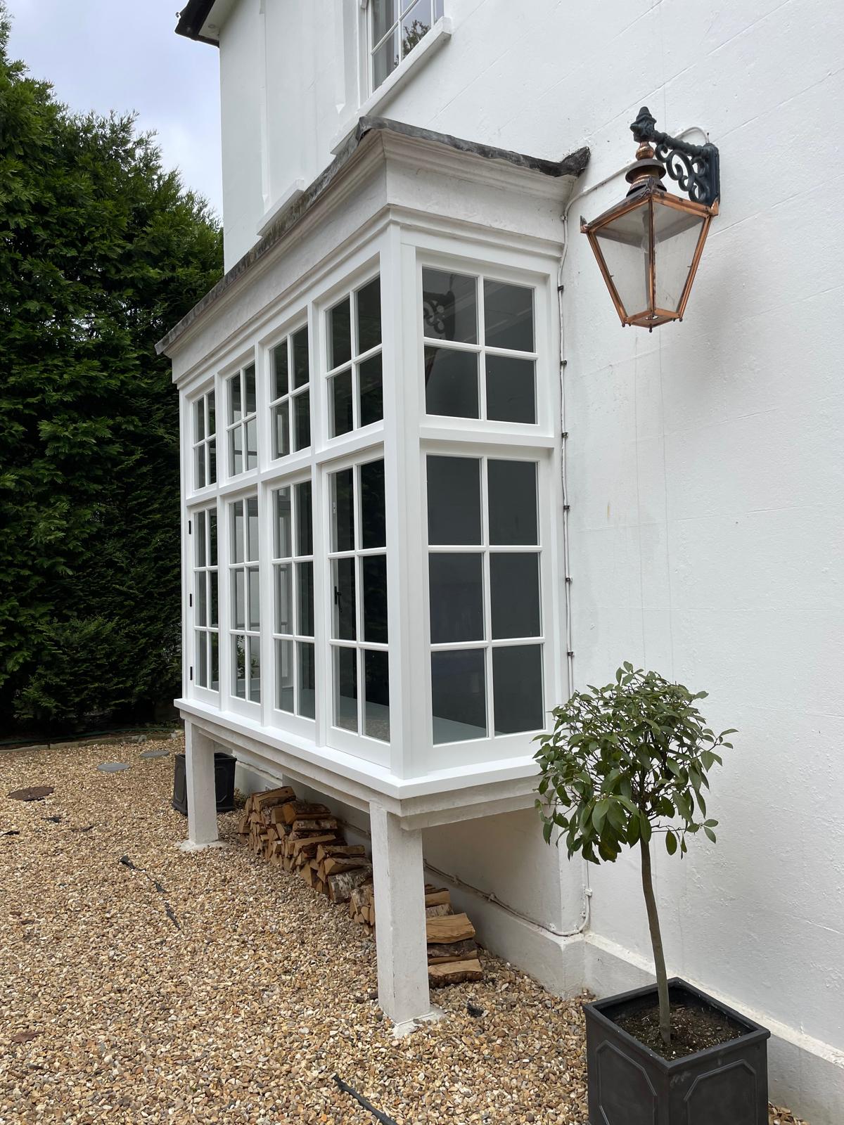 Maintained white box bay window on a rendered period property