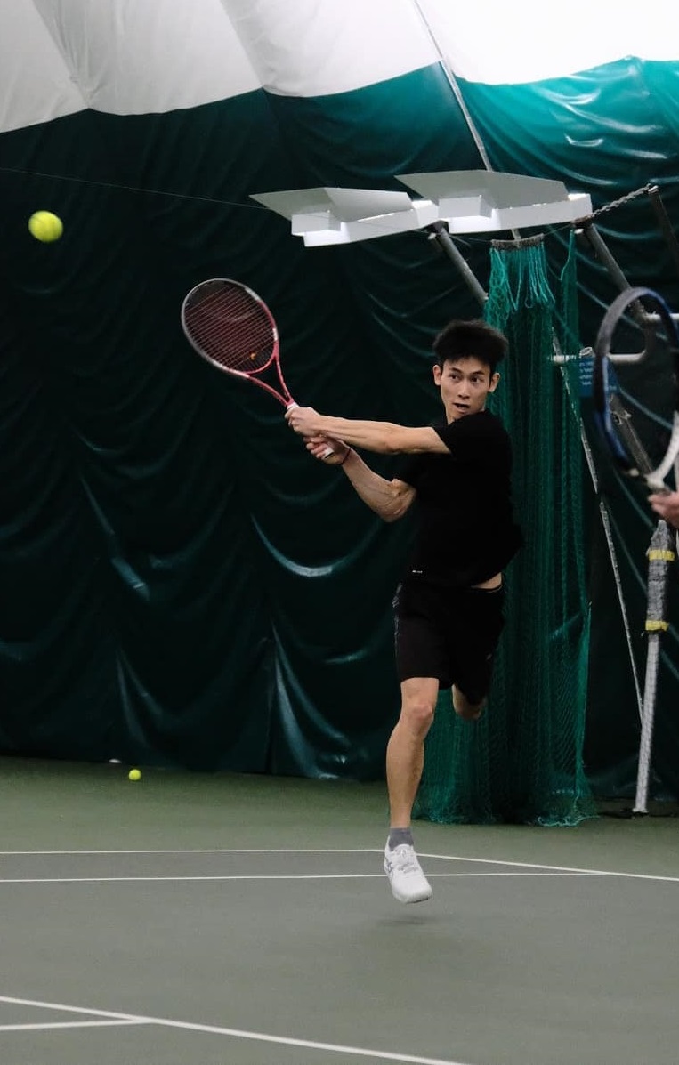 Coach Xiuneng Wang teaching tennis