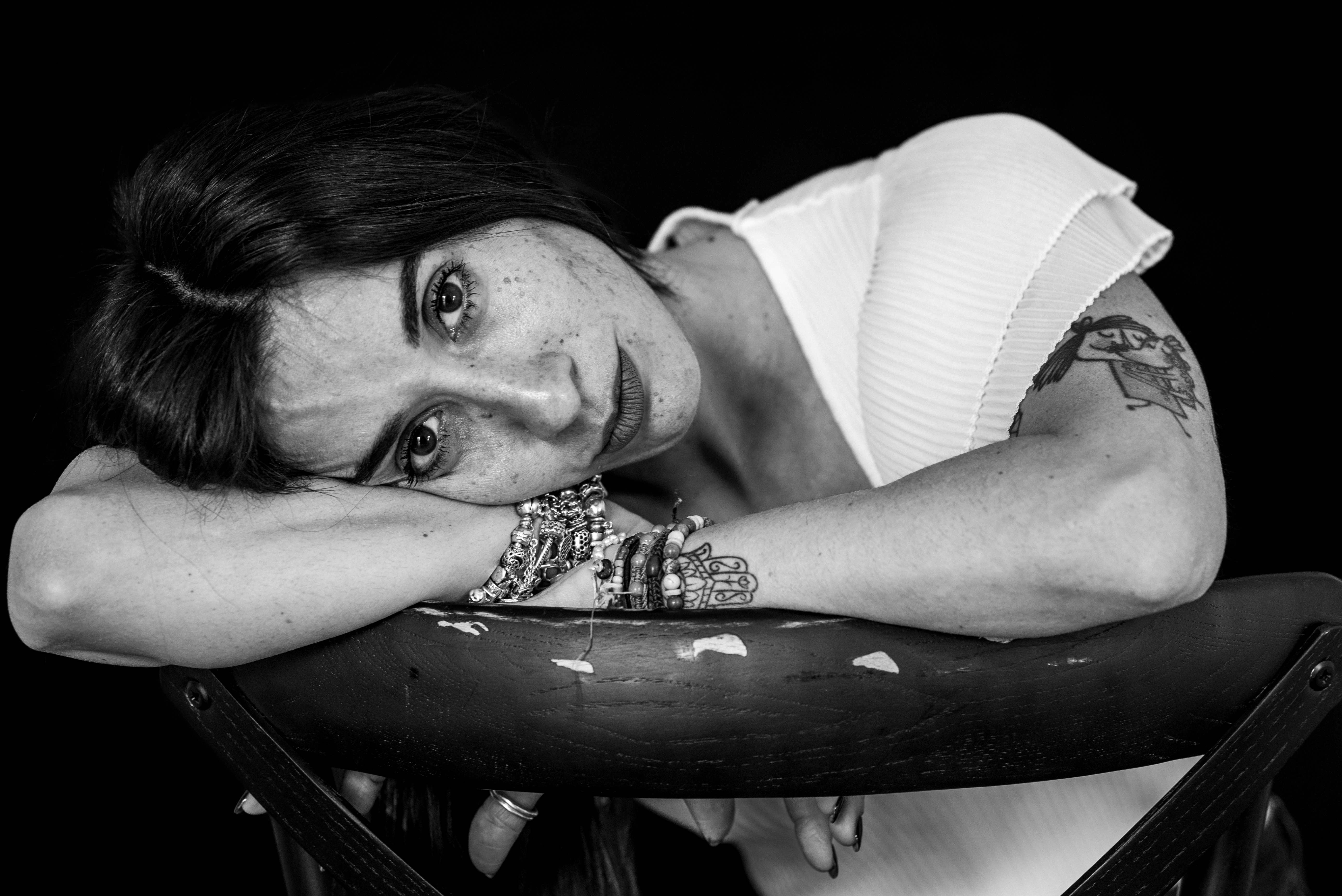 Woman resting head on arms on chair