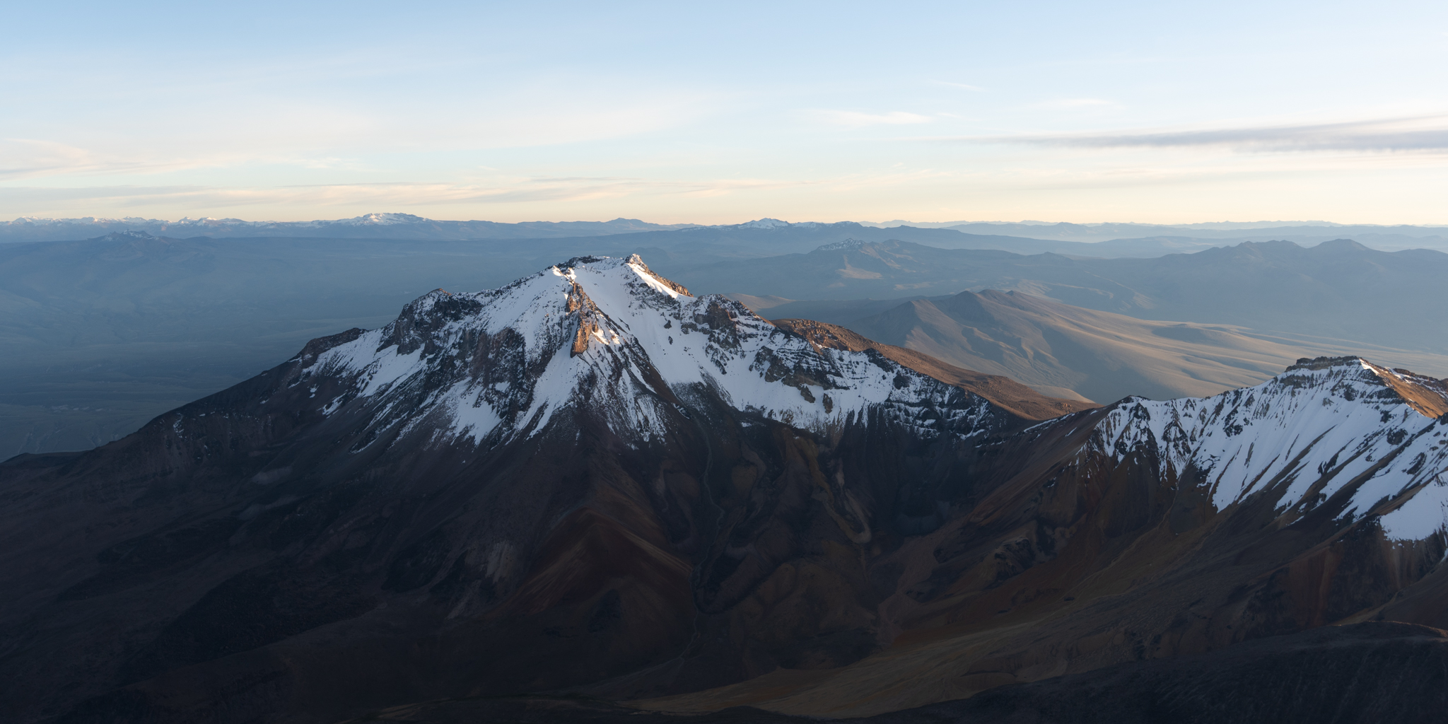 Snow-capped mountain peak aerial view at golden hour