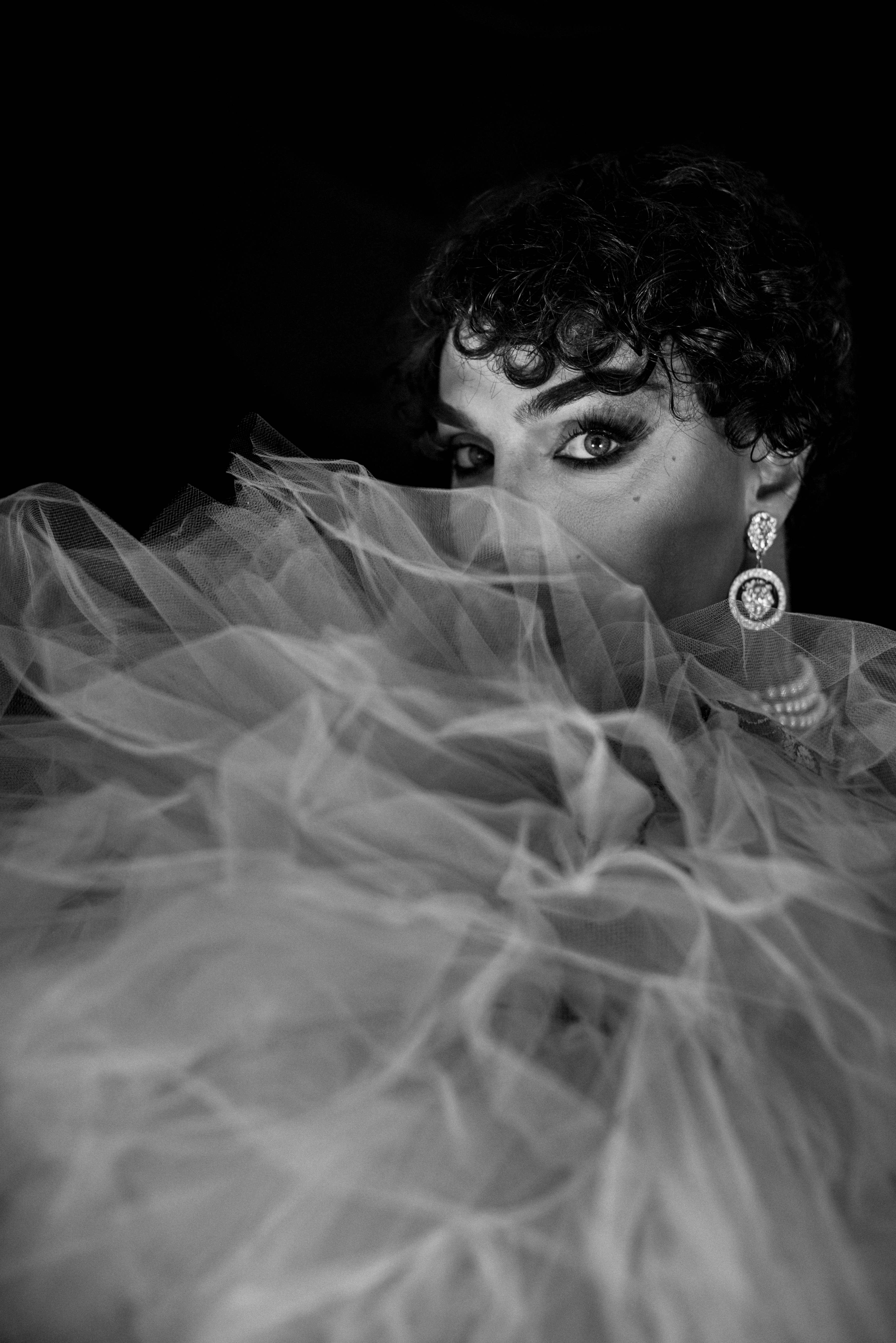 Dramatic portrait with curly hair and tulle