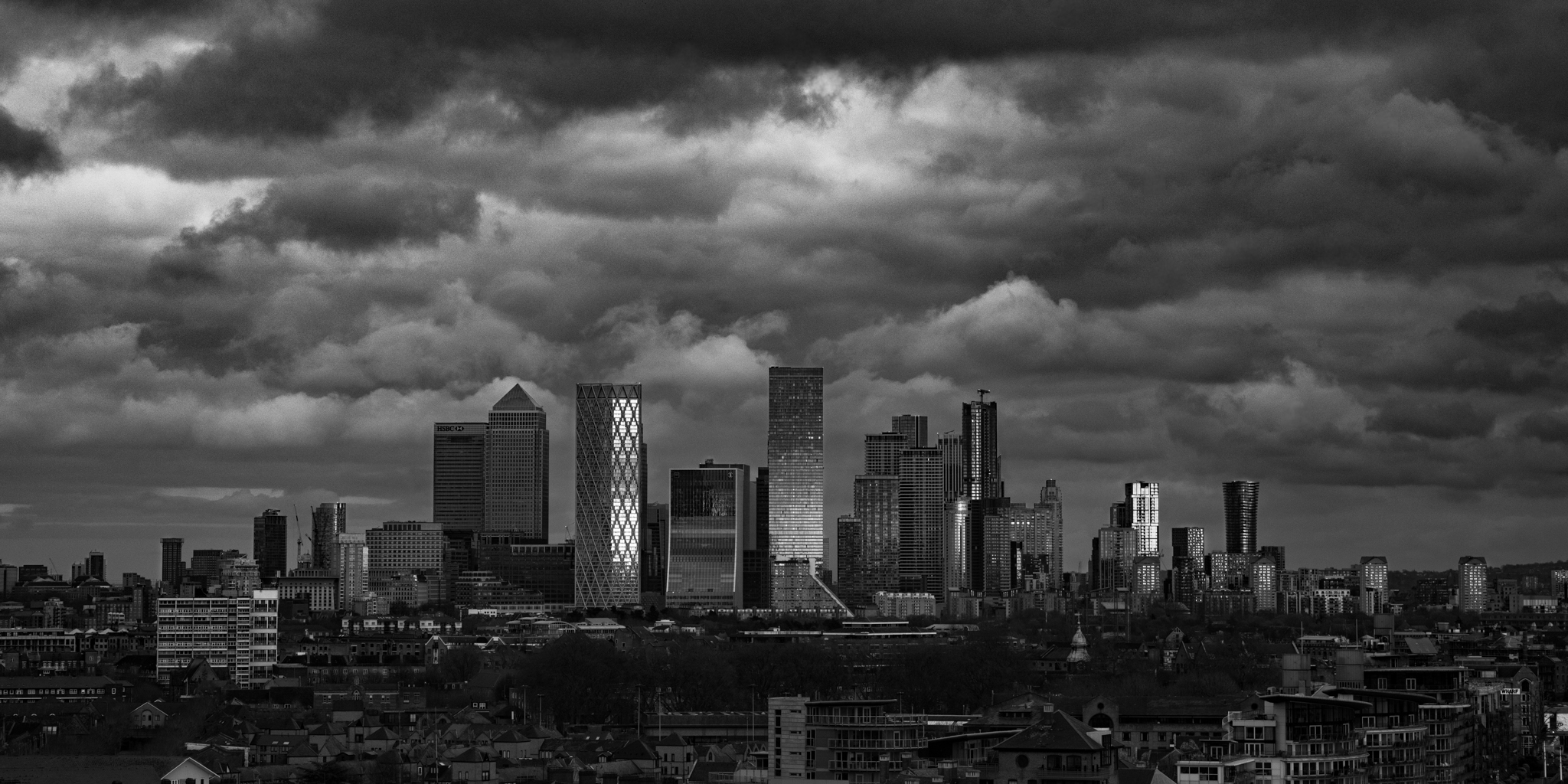 London Canary Wharf skyline under dramatic storm clouds