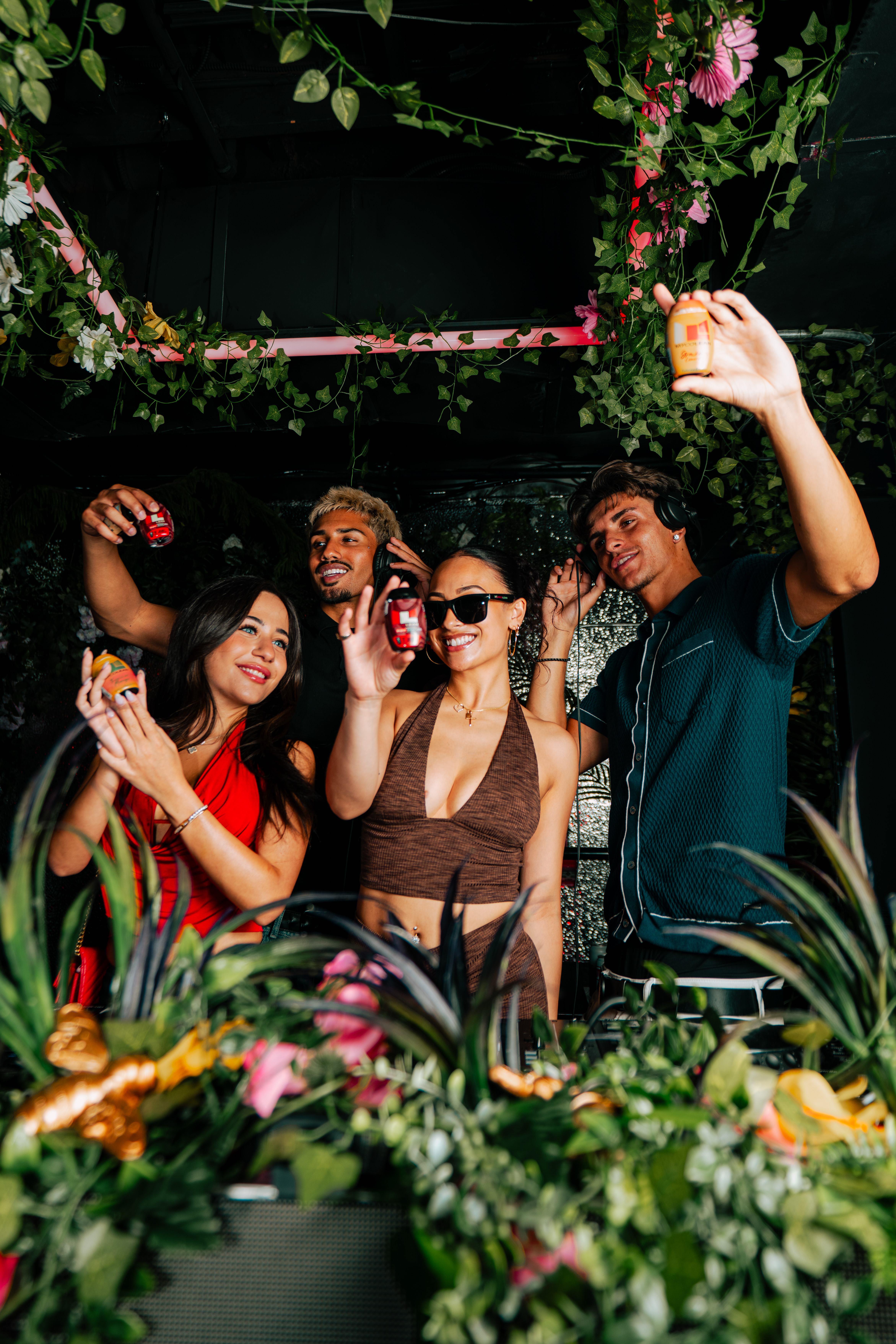 Group at a DJ booth surrounded by plants
