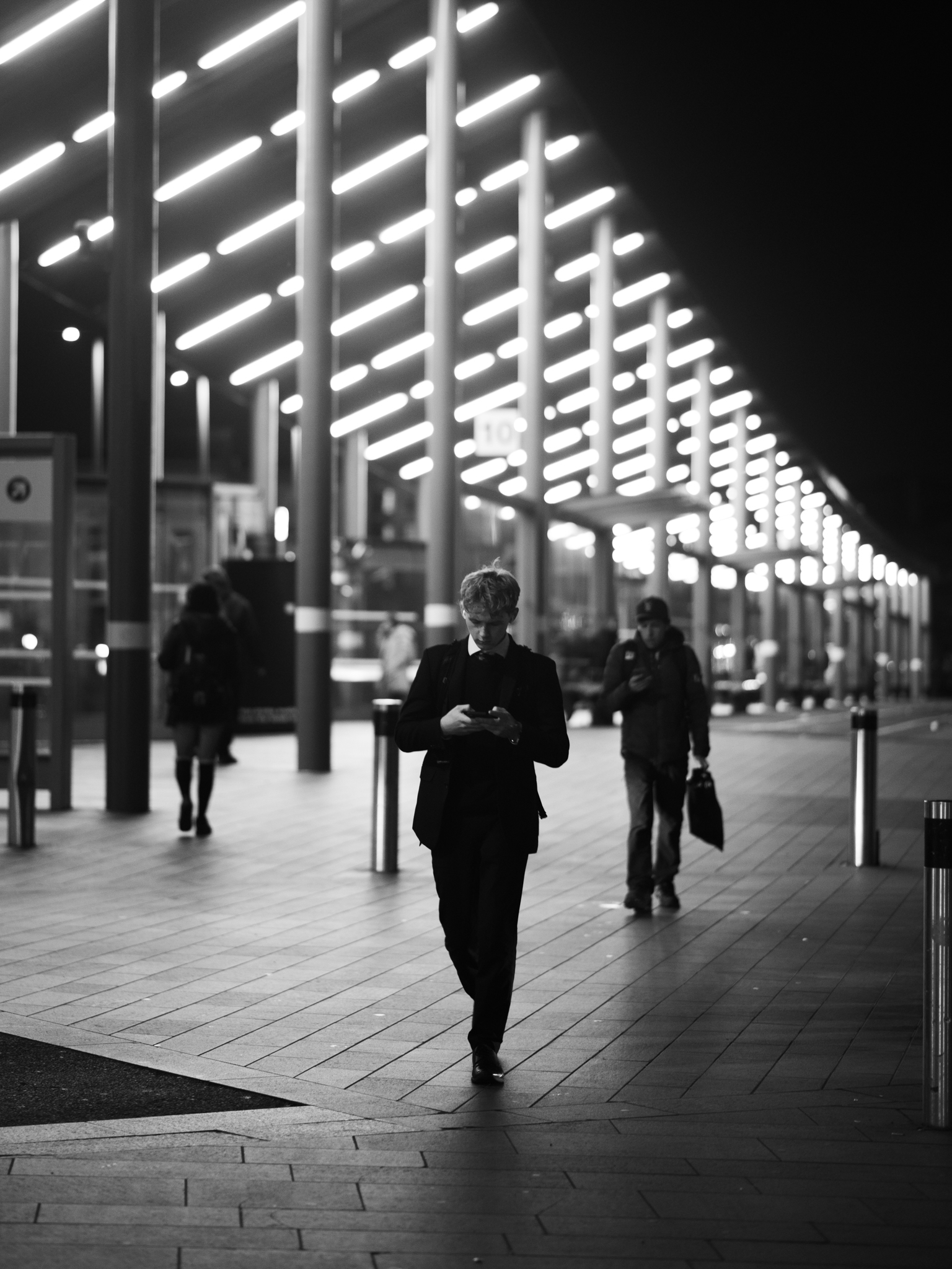 Man walking under lit canopy at night