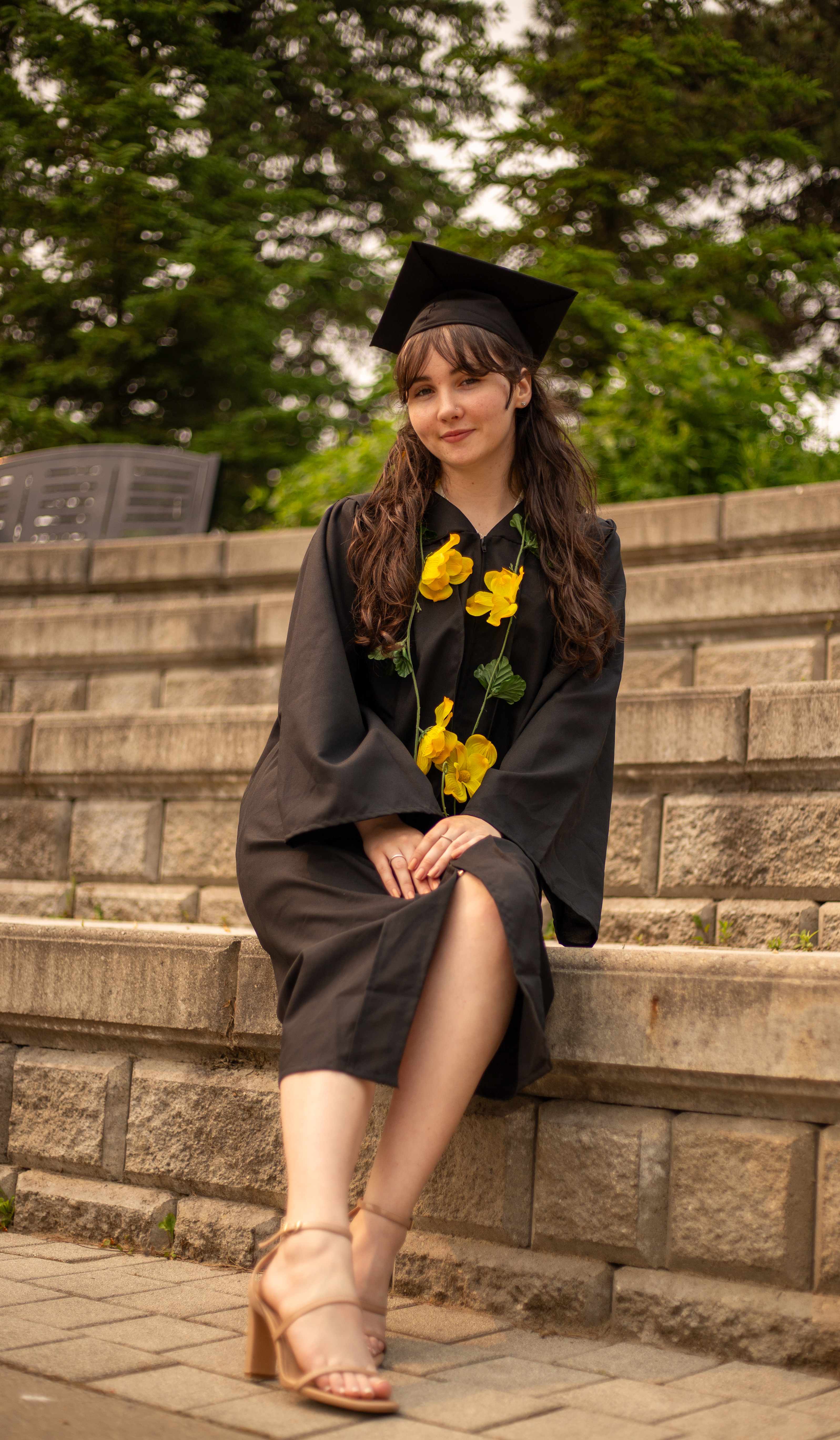 Graduate sitting on stone steps