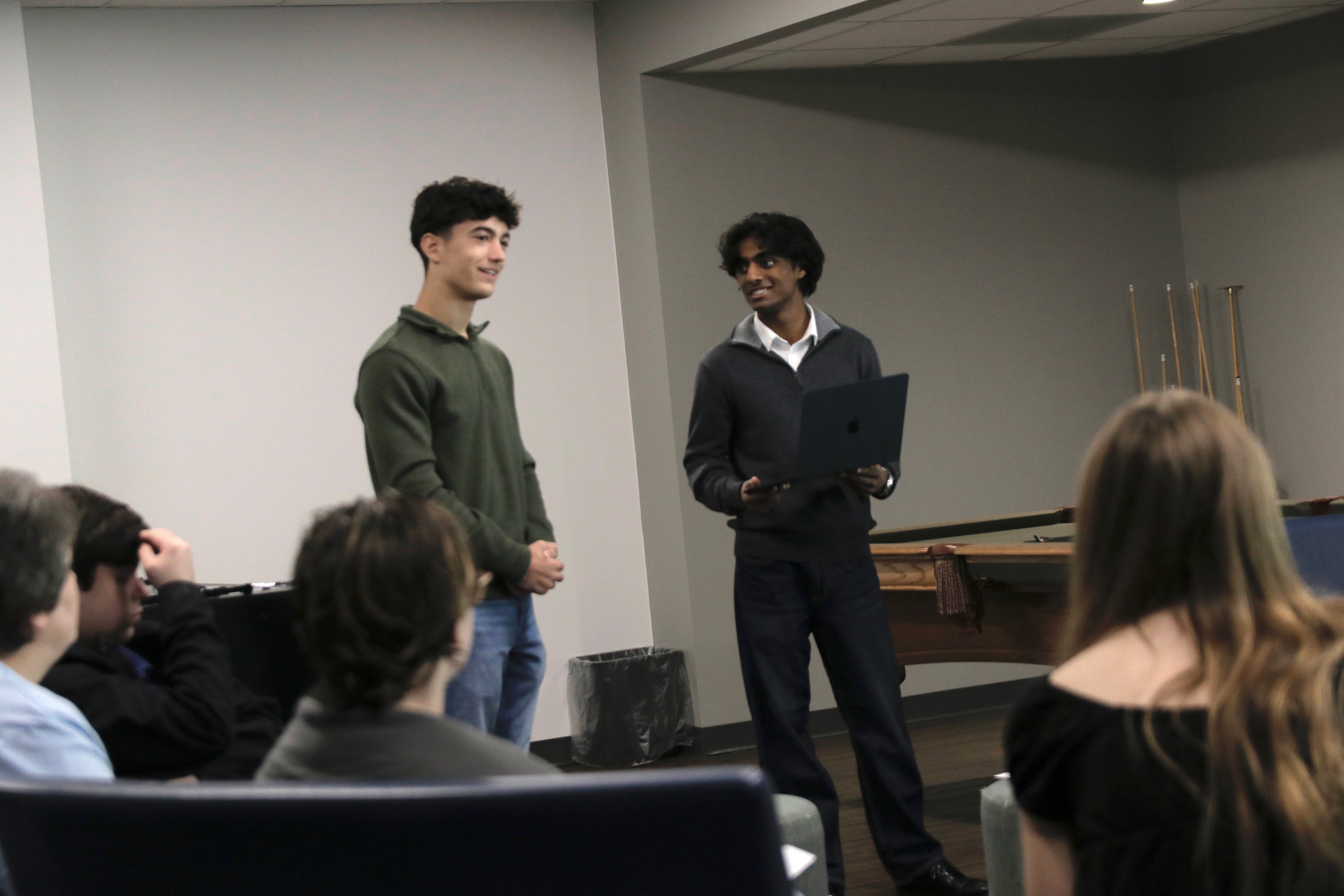 The founders leading a small-group presentation with a laptop
