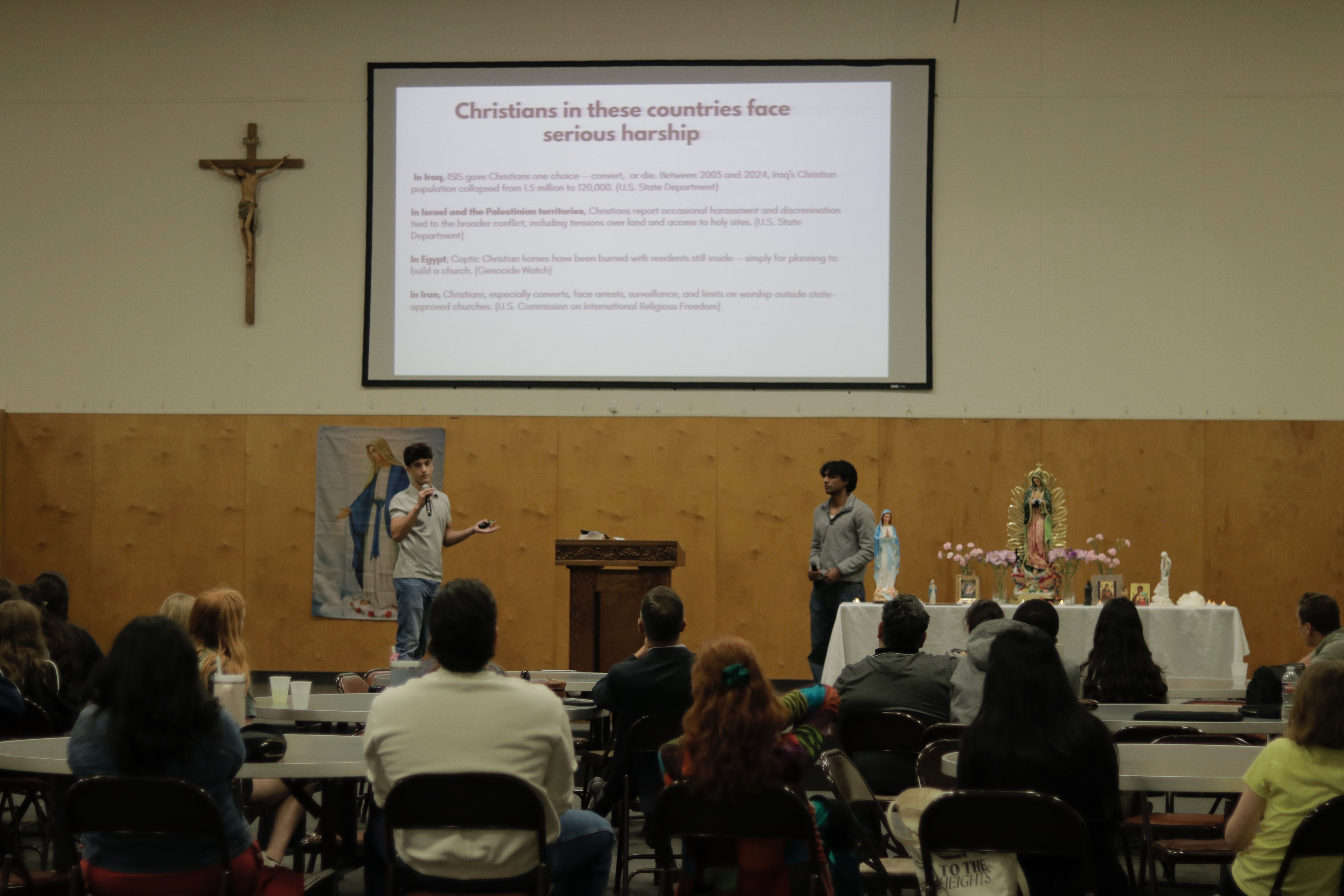 Presenting a slide on the hardship Christians face across the Middle East to a seated audience