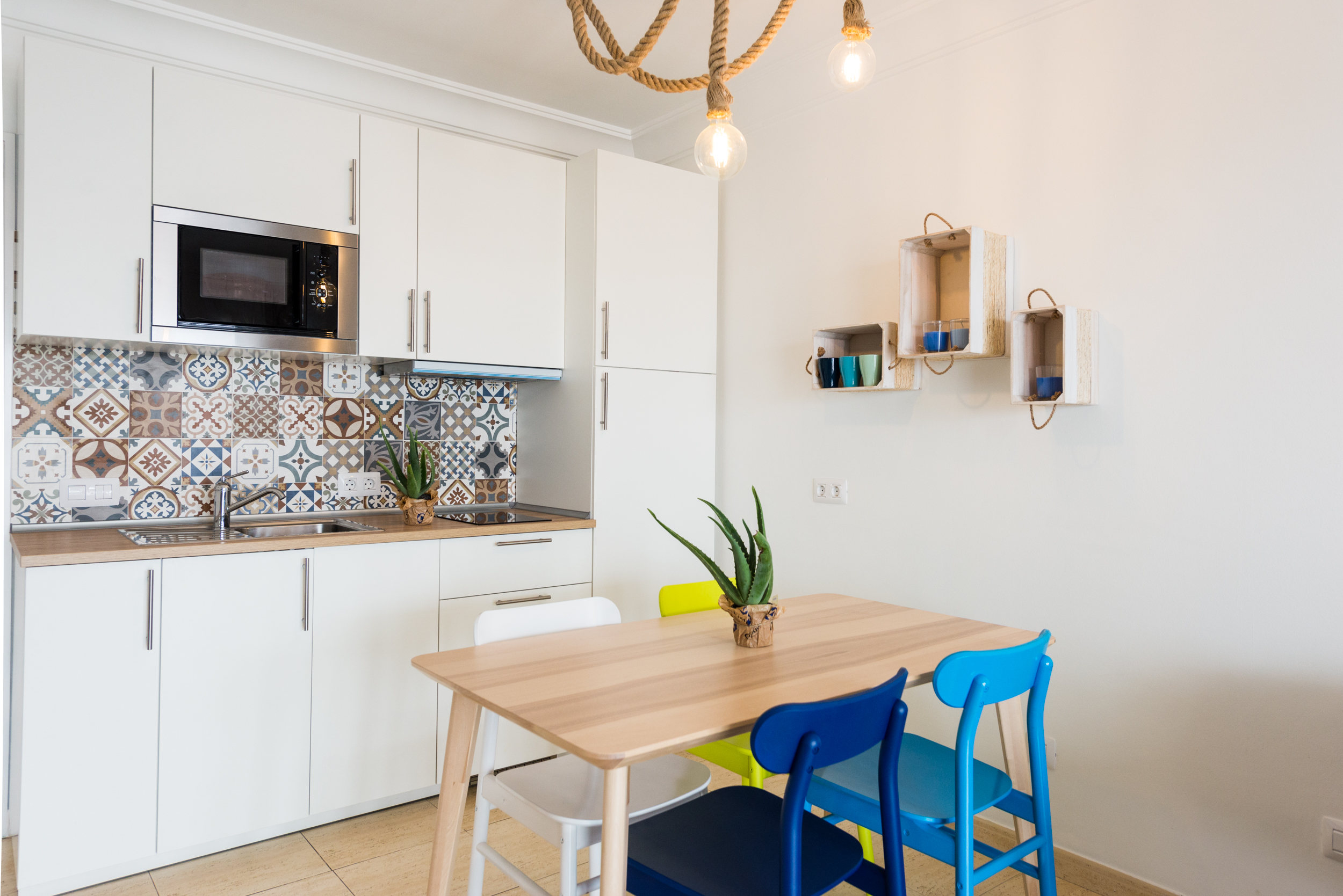 Kitchen with Moroccan-style backsplash tiles and colourful dining chairs
